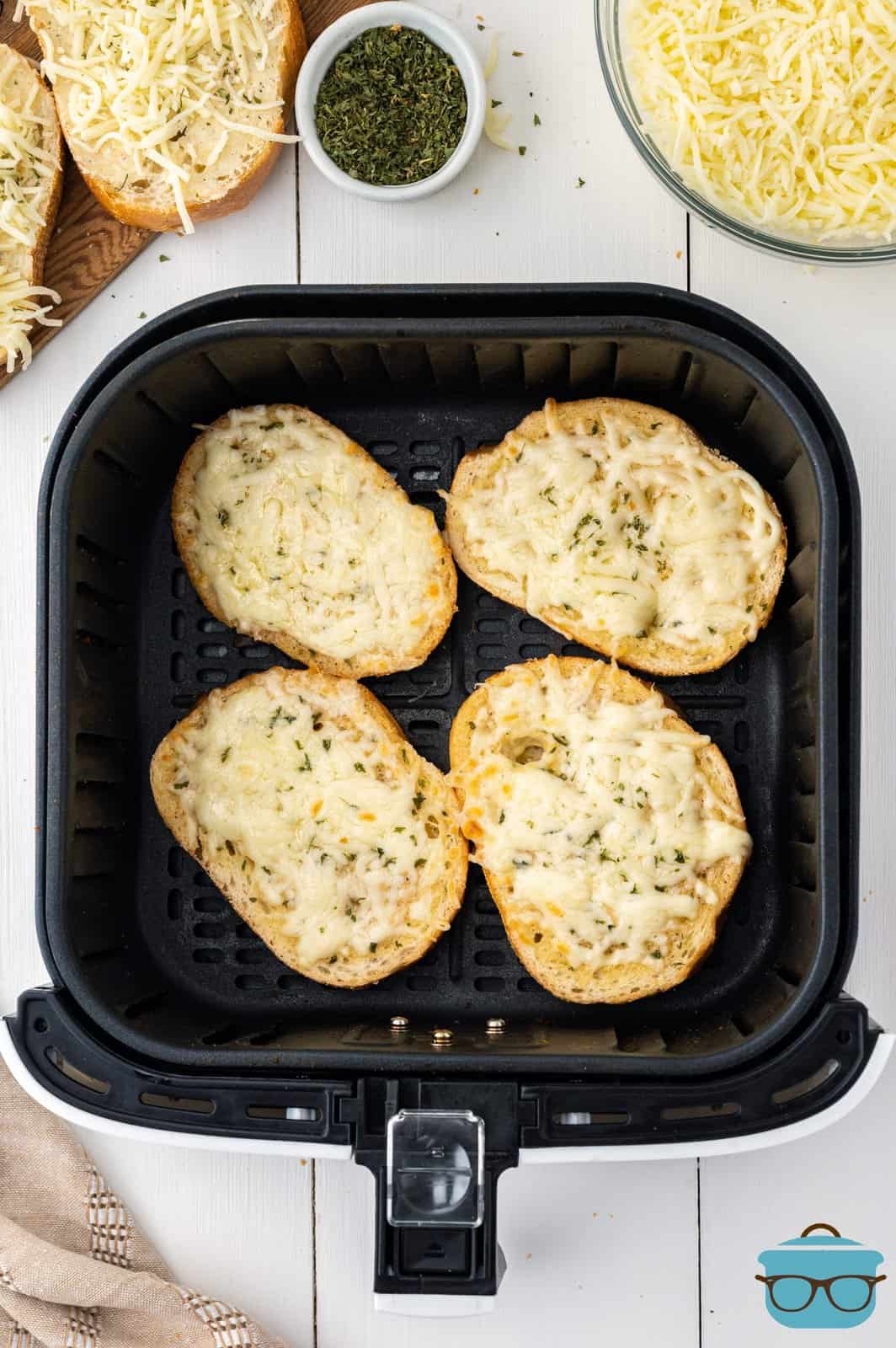 An Air Fryer basket with 4 slices of garlic bread.