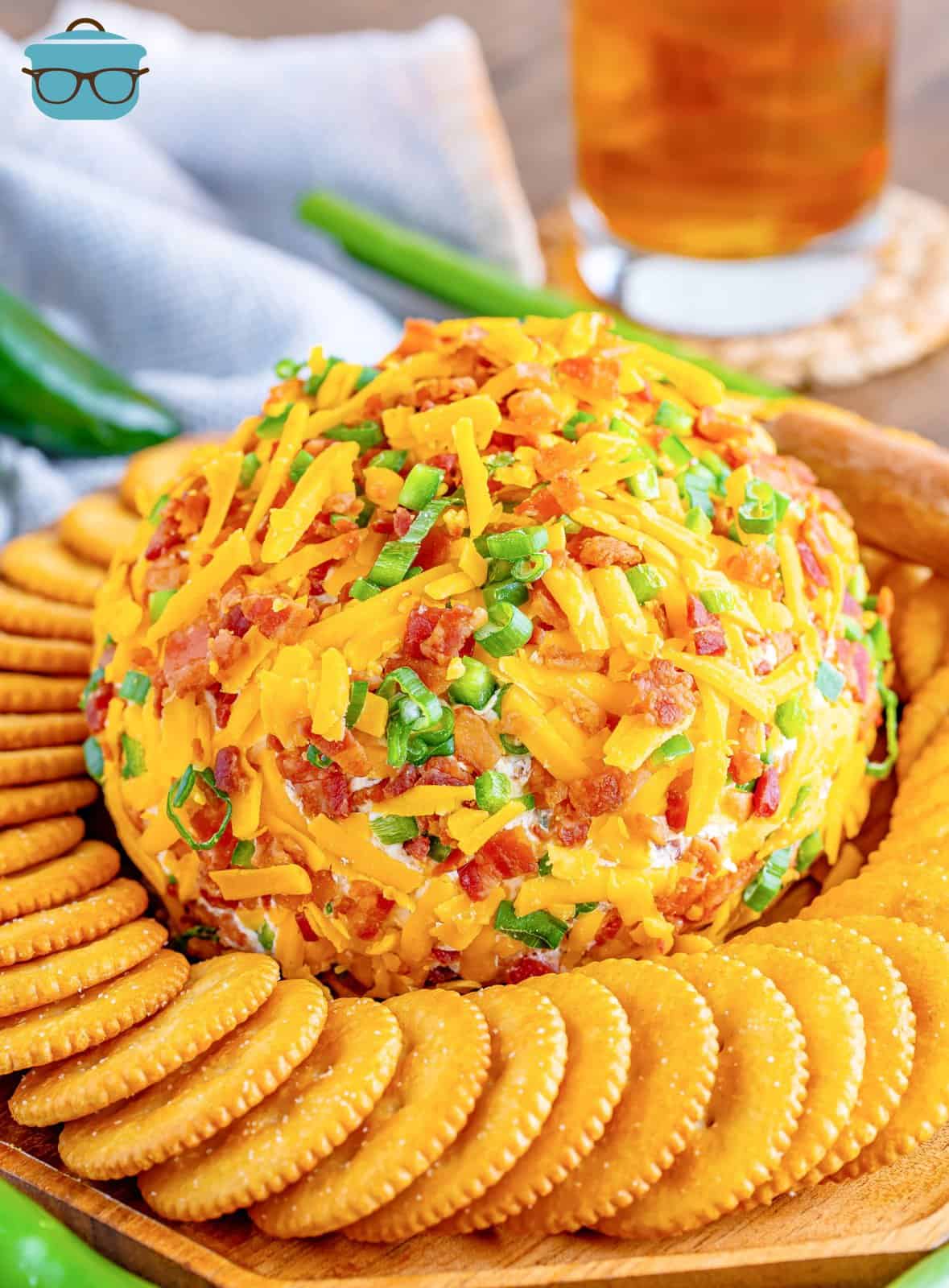 A full ball of Jalapeno Popper Cheeseball with a ring of crackers around it.