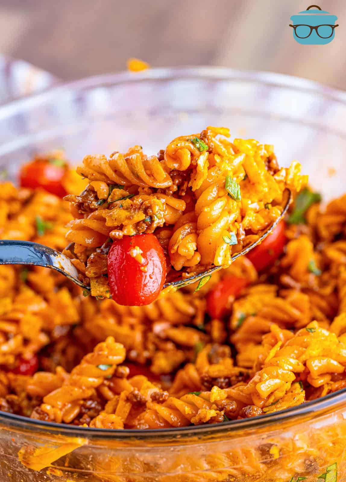 A bowl of taco pasta salad with tomatoes.