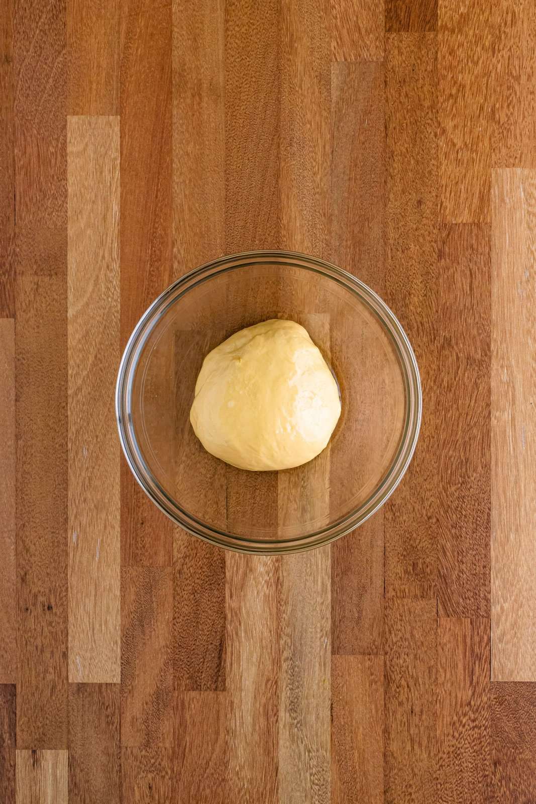 Dough that is rising in a glass bowl.