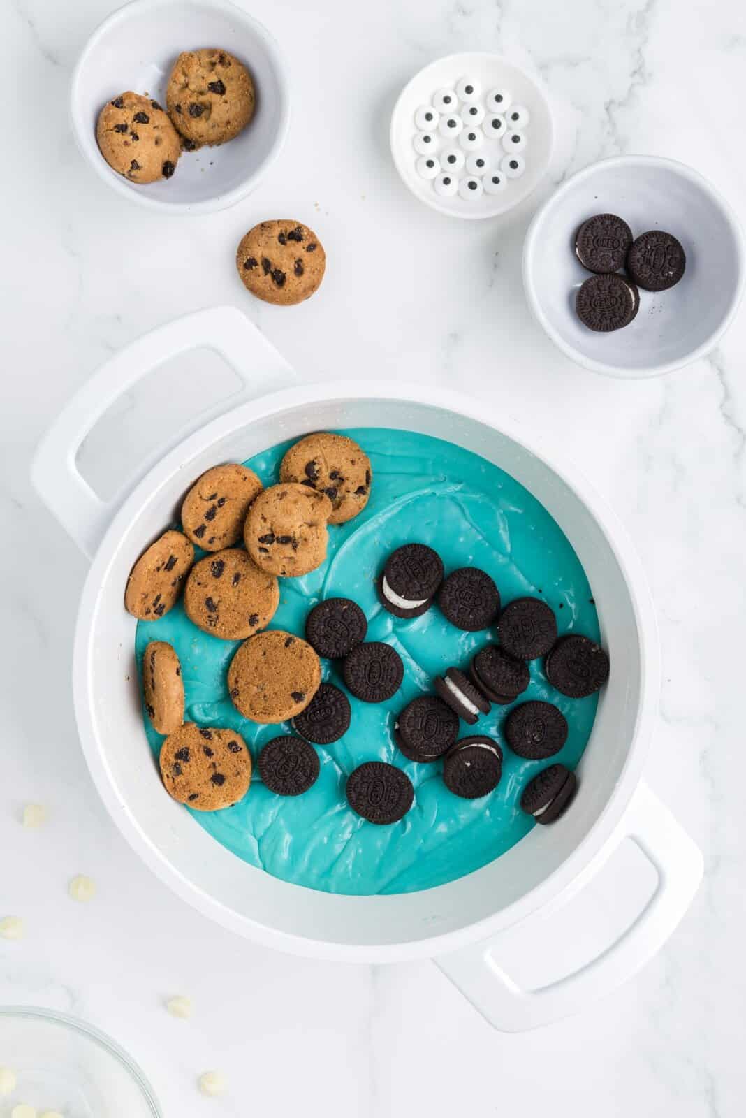 A large pot with blue fudge and Oreos and Chips Ahoys on top.
