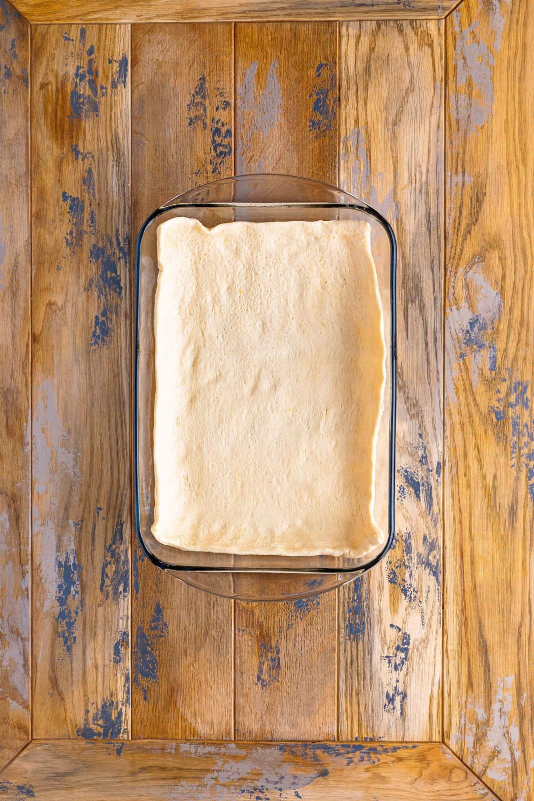 A baking dish with crescent roll dough.