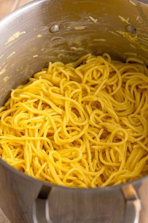 Spaghetti with butter, cheese, and eggs in a pot.