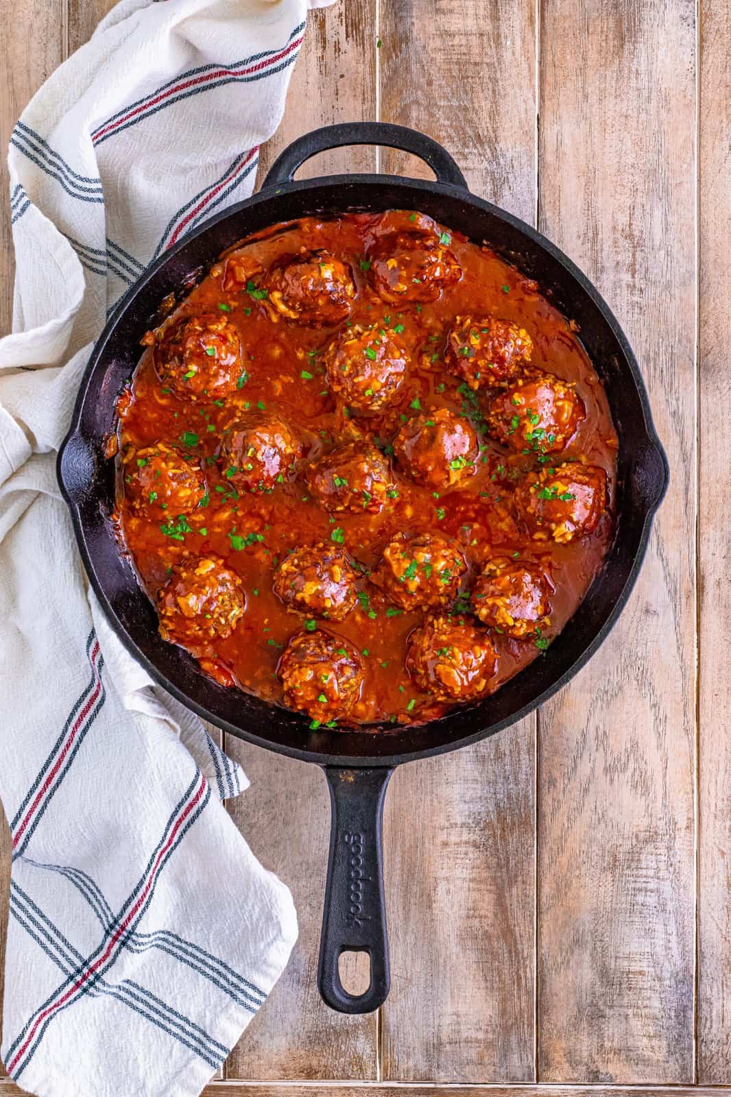 Looking down on Porcupine Meatballs with sauce in a cast iron skillet. 