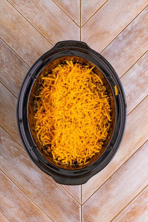 Shredded cheese on top of food in a crockpot.