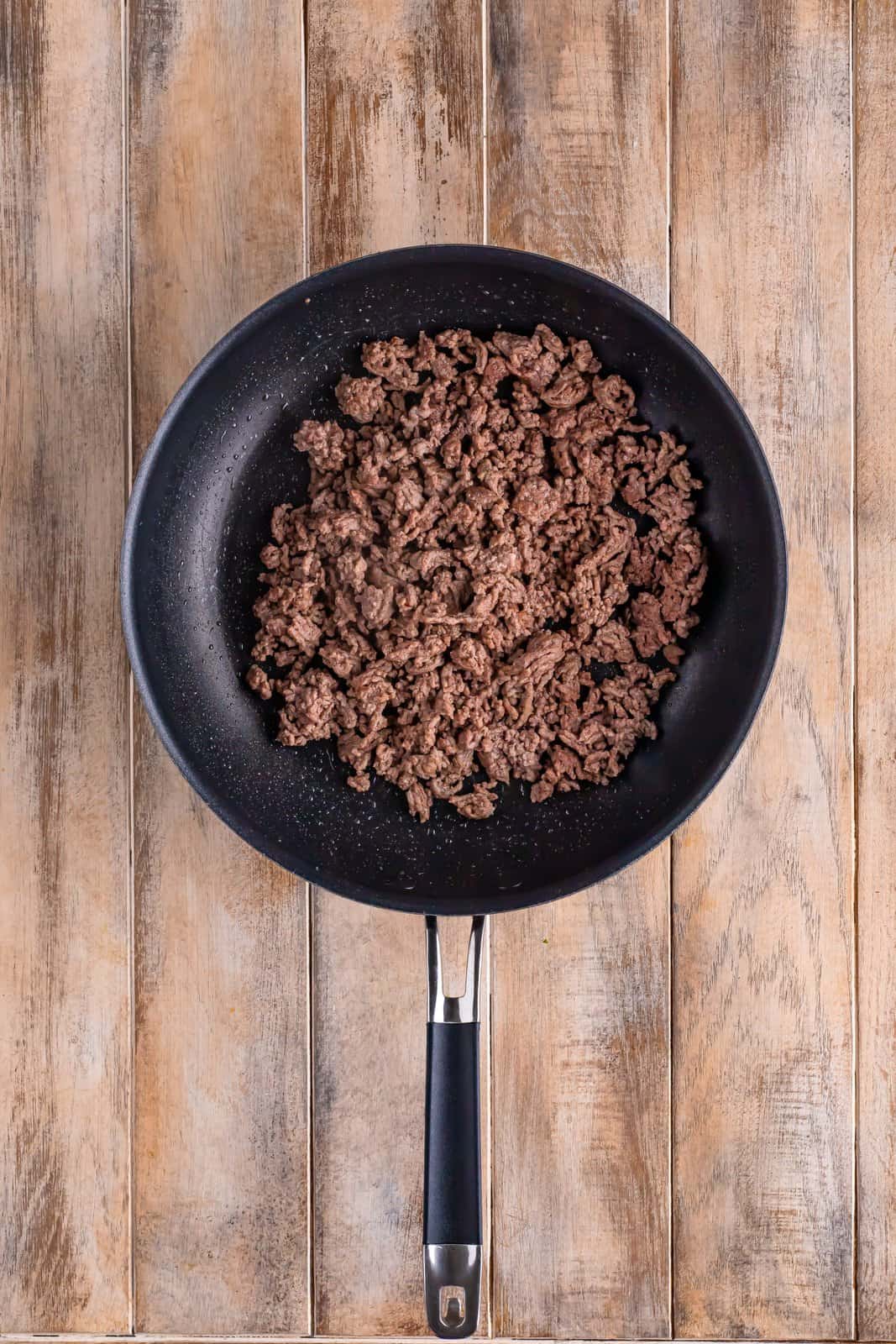 Skillet with cooked ground beef.