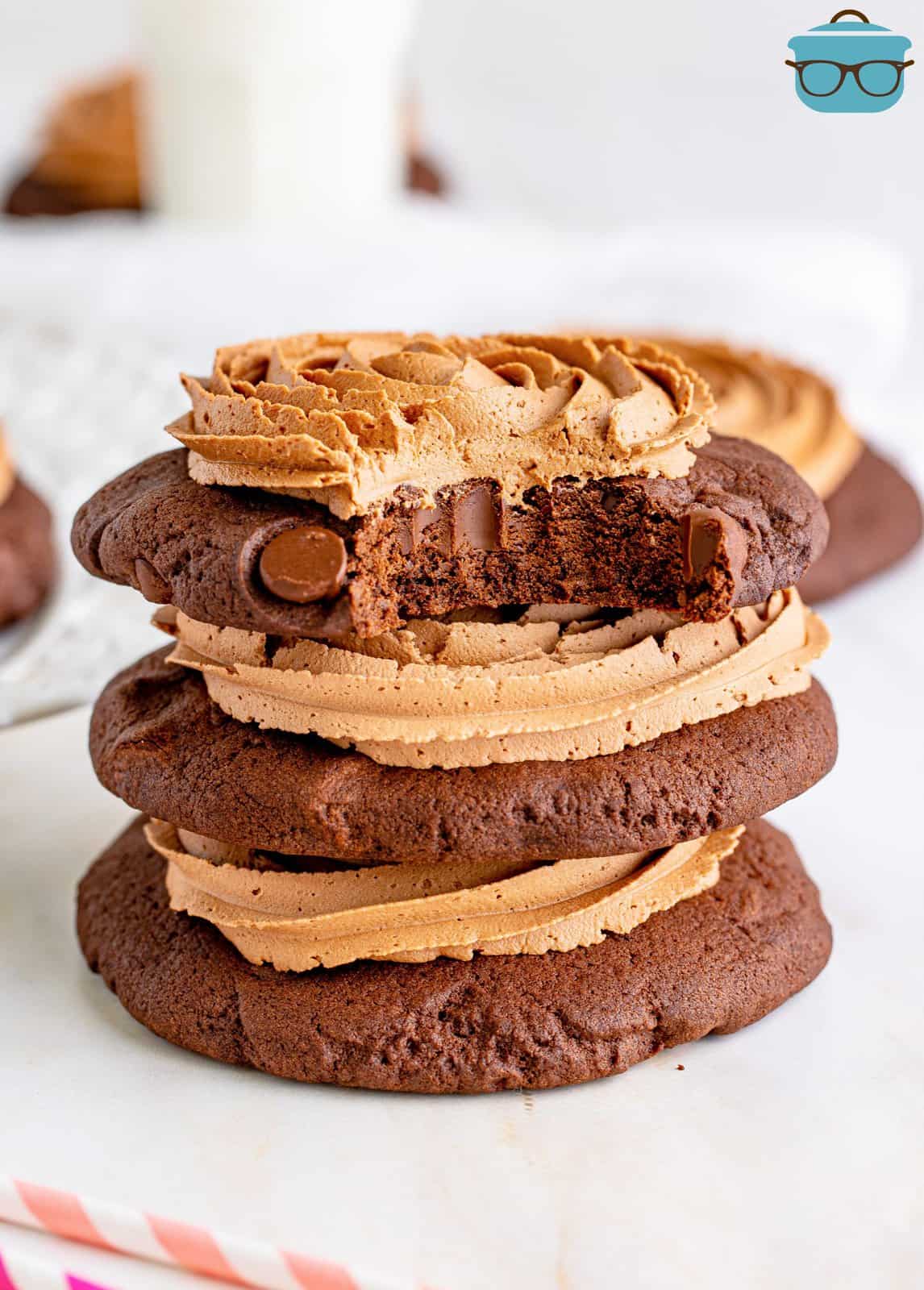 Three chocolate cake cookies with icing in a stack.