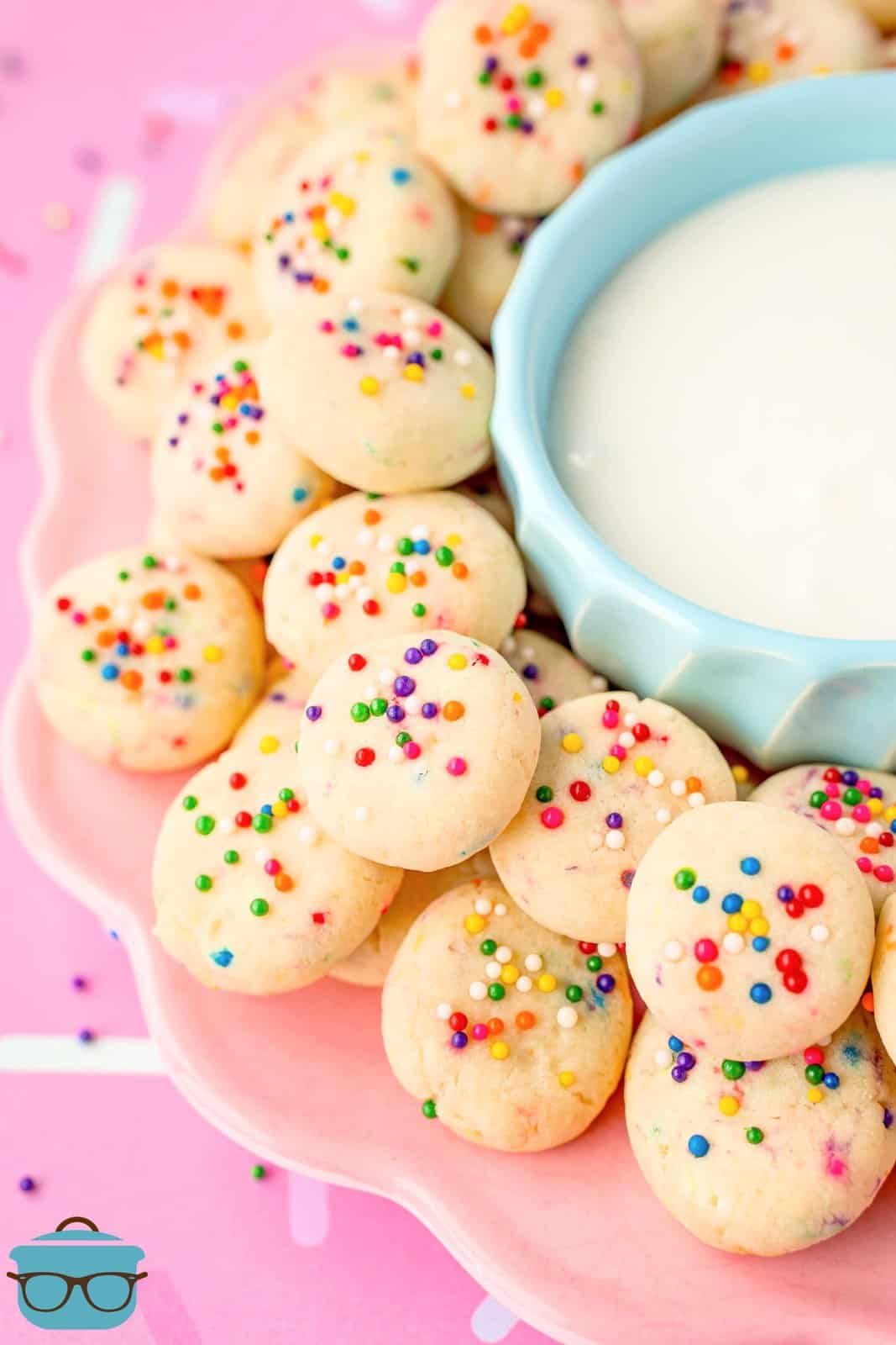 A blue bowl surrounded by small sweetened condensed milk cookie bites.
