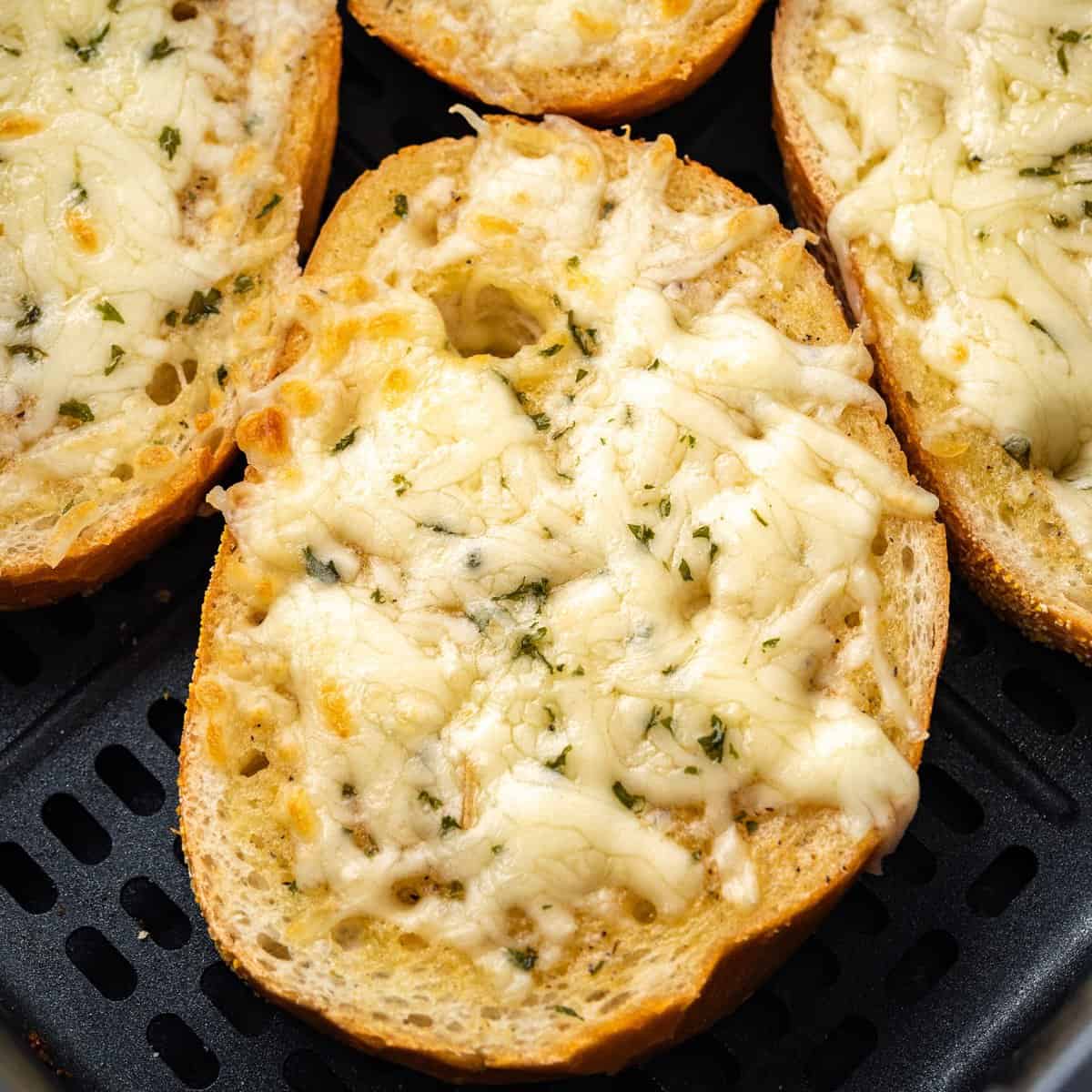 A close up looking at a piece of cheesy garlic bread.