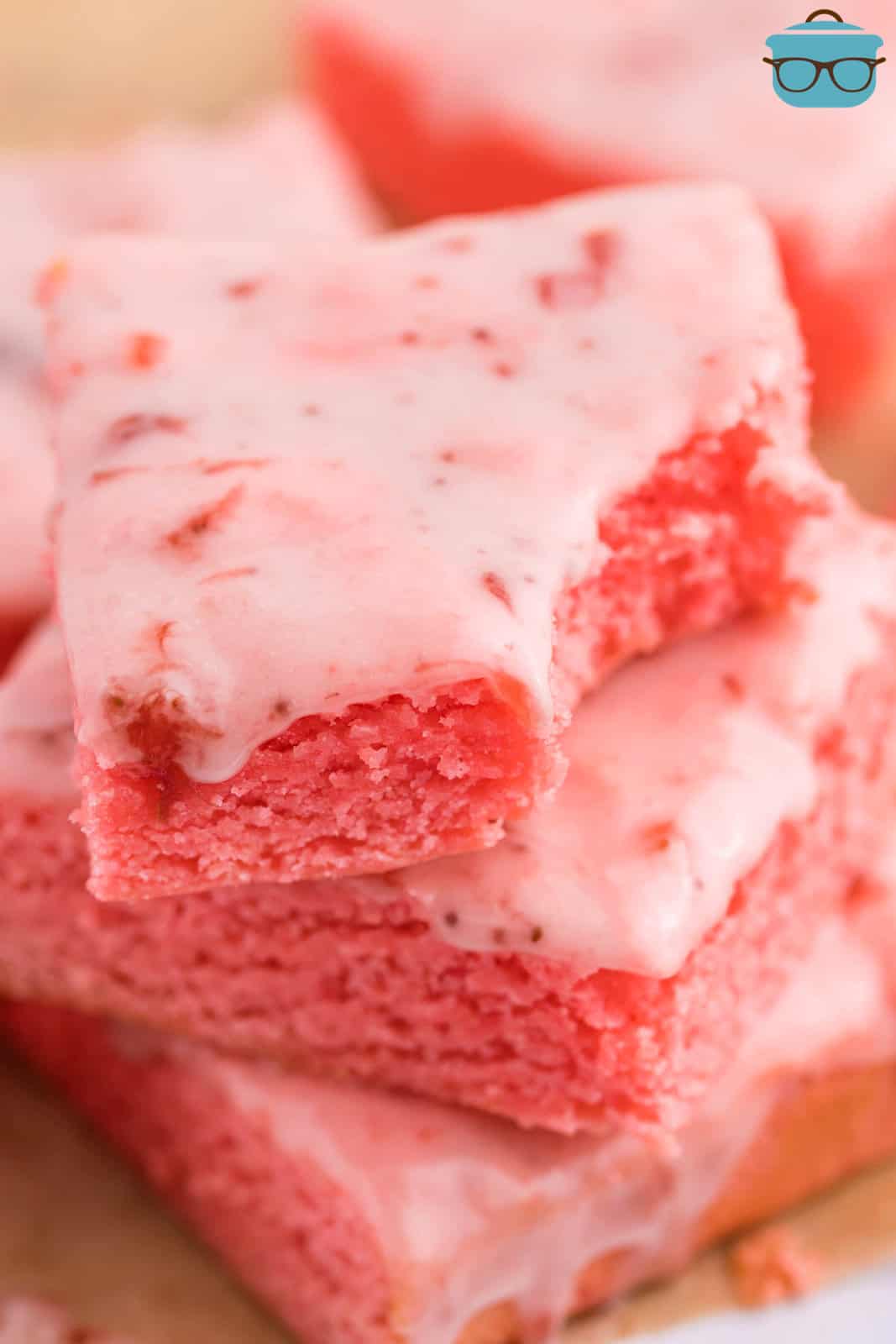 A stack of Strawberry Brownies with a bite taken out of one. 