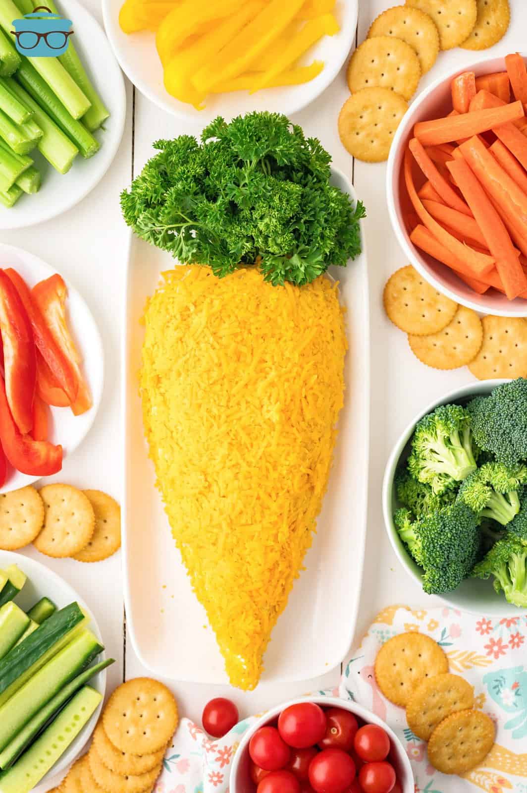 A carrot shaped cheeseball on a serving plate.