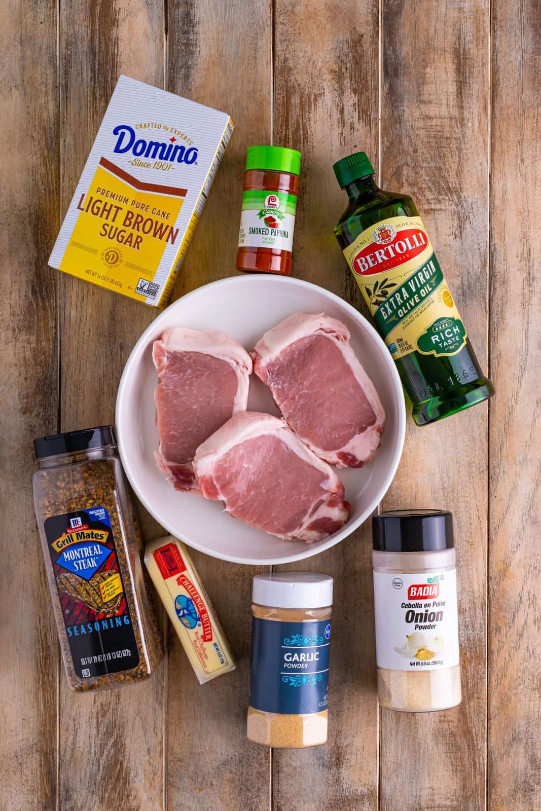 Pork Chops, olive oil, Montreal steak seasoning, light brown sugar, smoked paprika, onion powder, garlic powder, and salted butter.