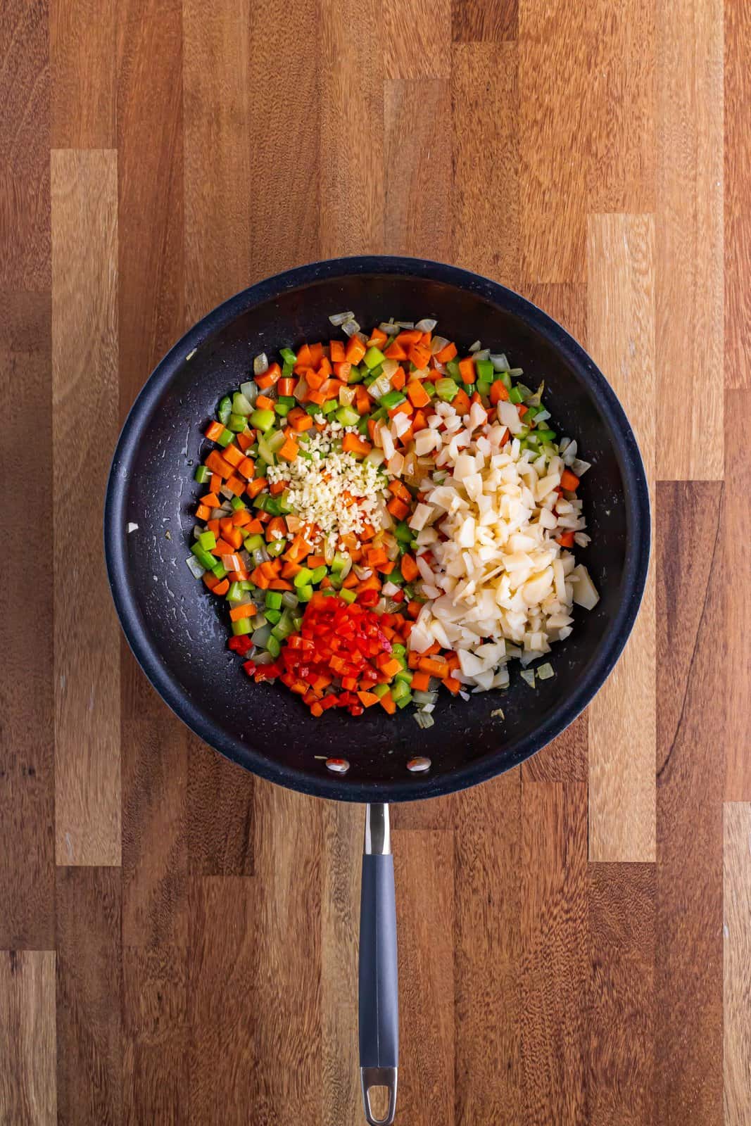 Skillet with celery, butter onion, garlic, pimentos and water chestnuts and carrots all mixed together and sauteed.
