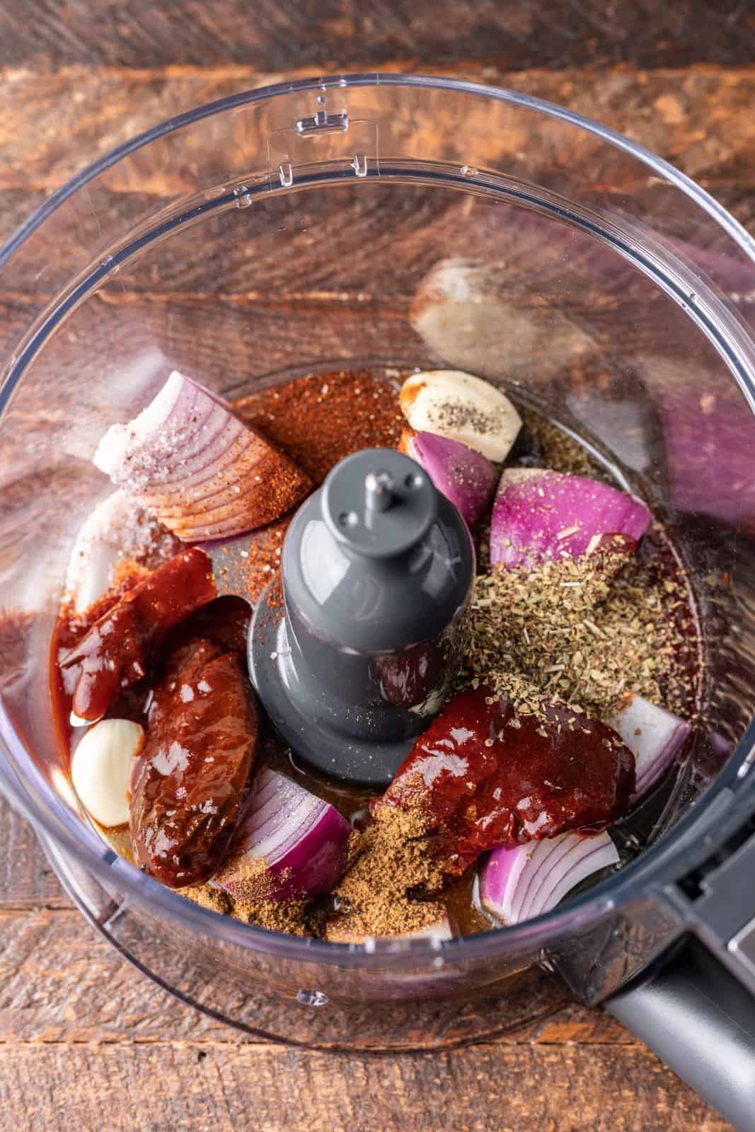 Onions and a bunch of spices and herbs in a food processor. 