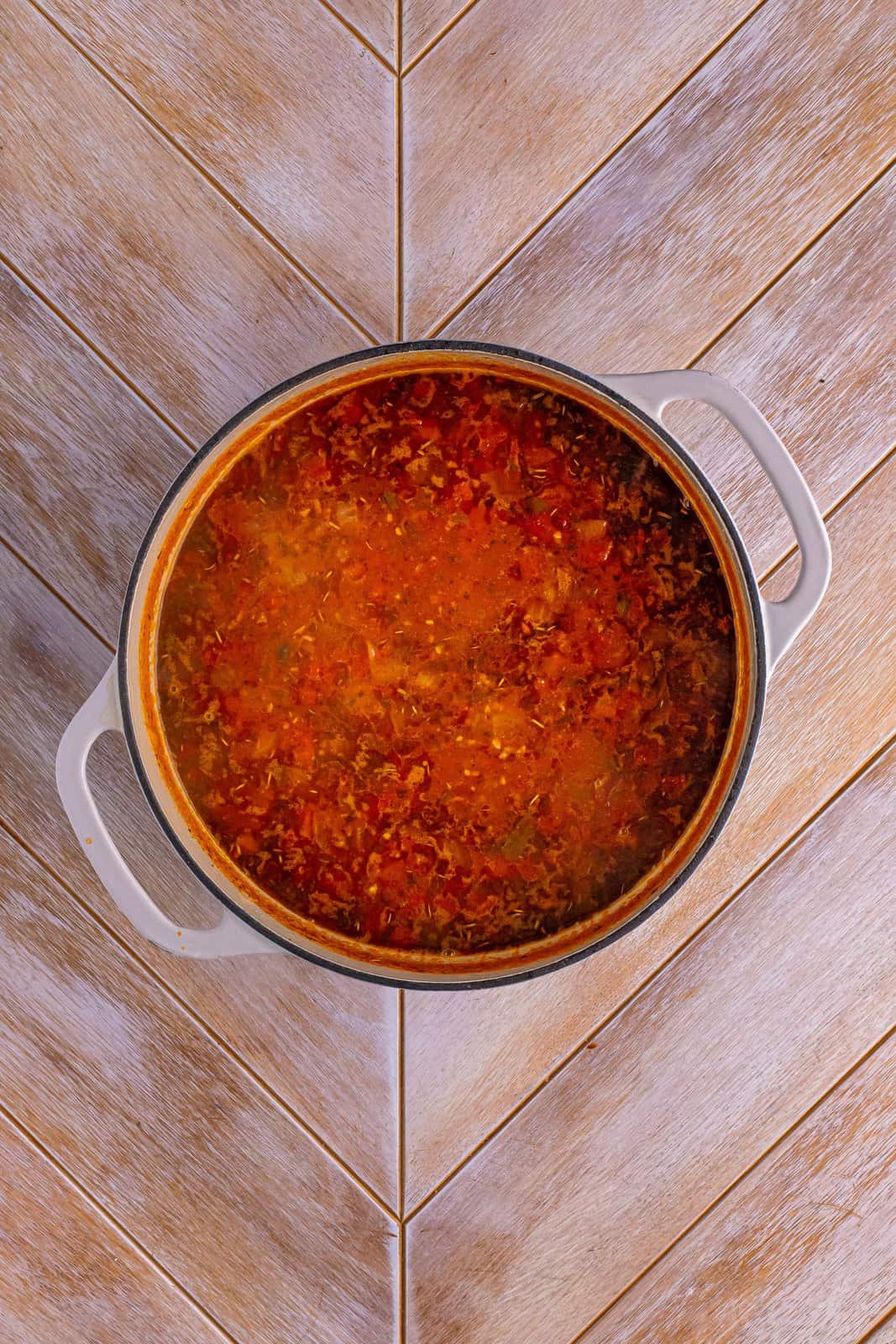 A pot with red tomato based soup in it.