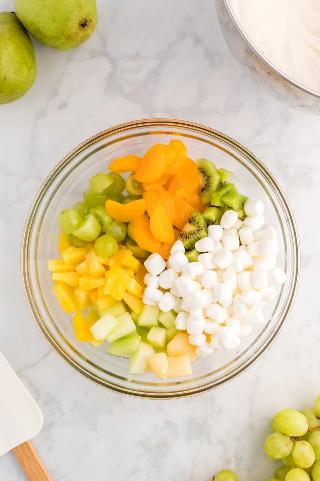 A large mixing bowl with the fruit and marshmallows for St. Patrick's Day Ambrosia Salad. 