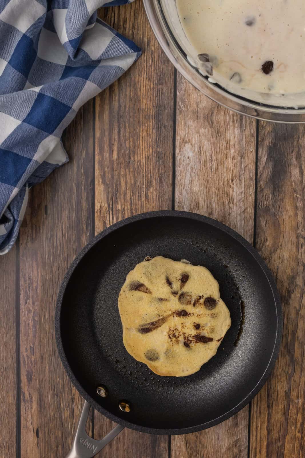 A Chocolate Chip Pancake in a hot skillet.