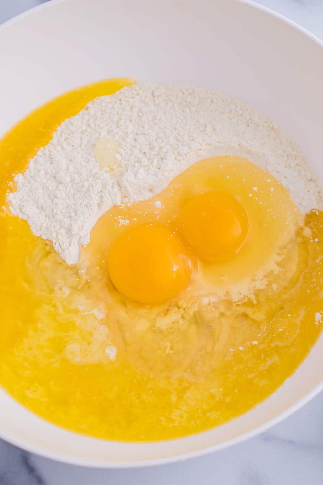 Eggs, lemon extract, and cake mix in a mixing bowl.