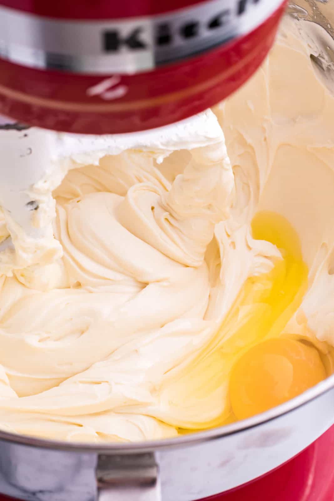 A cream cheese mixture with eggs in a mixing bowl.