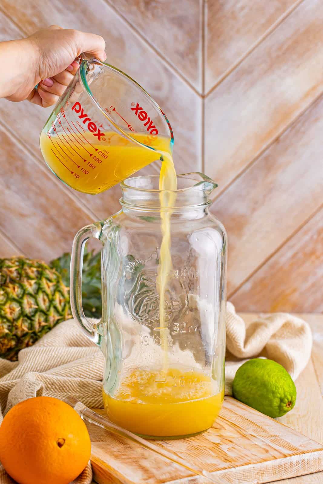 A pitcher with pineapple and orange juice.