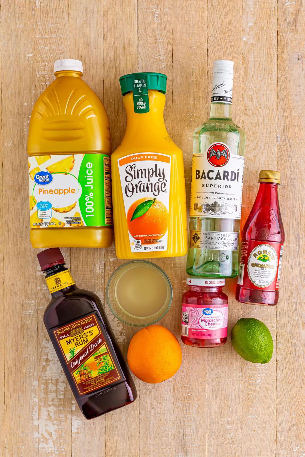 Pineapple juice, orange juice, grenadine, dark rum, white rum, orange, lime, and maraschino cherries.