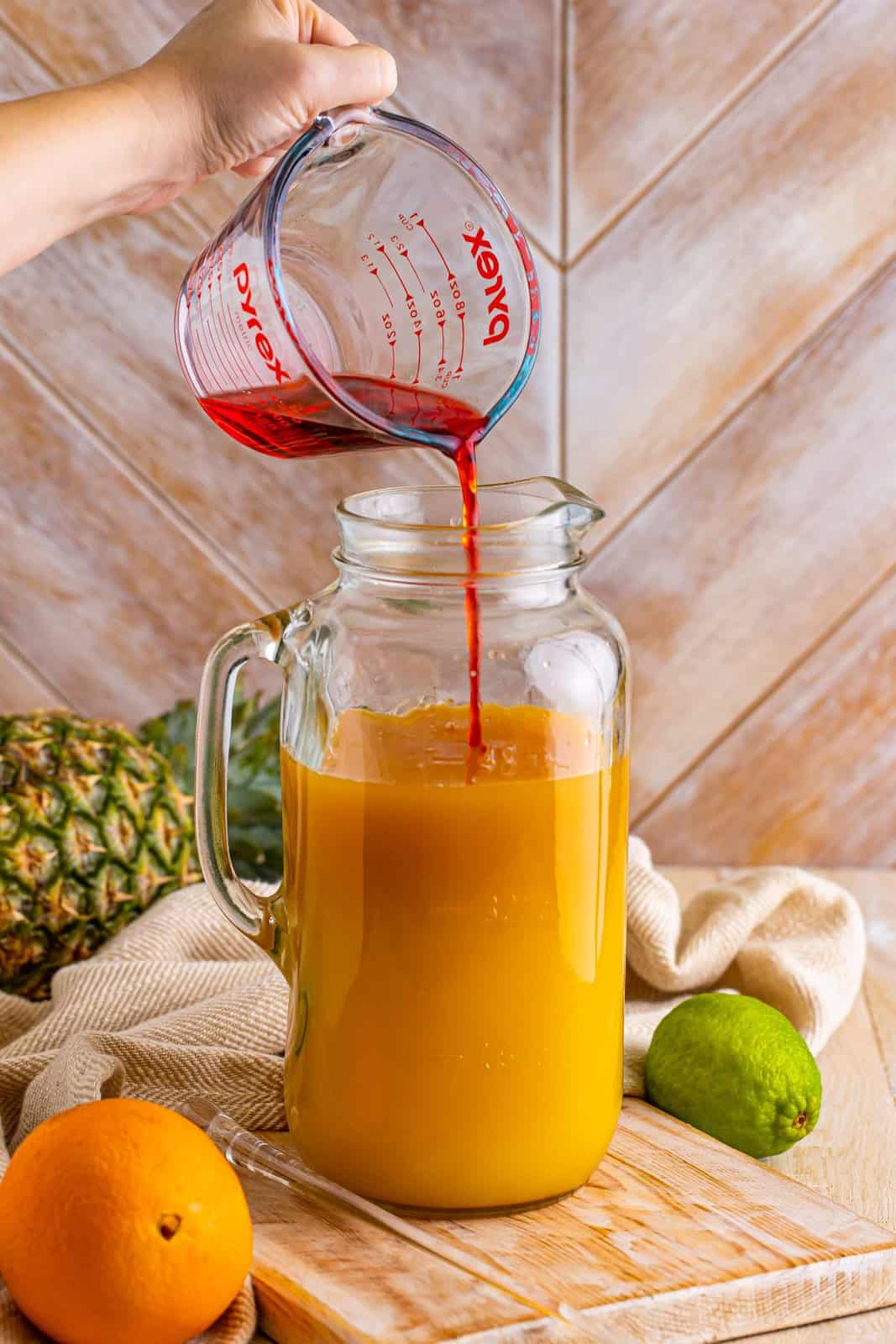 A pitcher with pineapple, orange juice, dark rum, grenadine, and white rum.