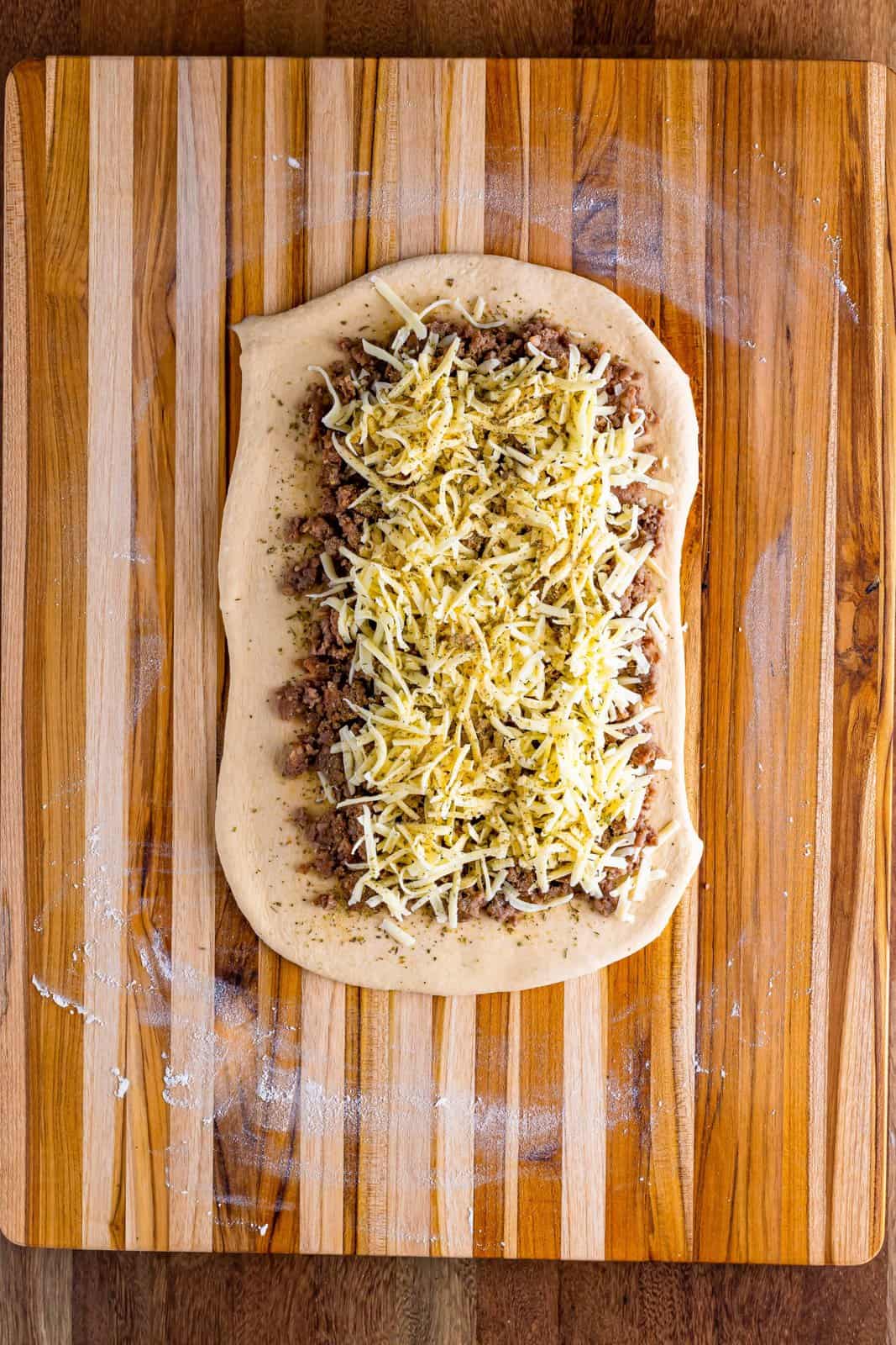Dough with sausage, spices, and cheese.