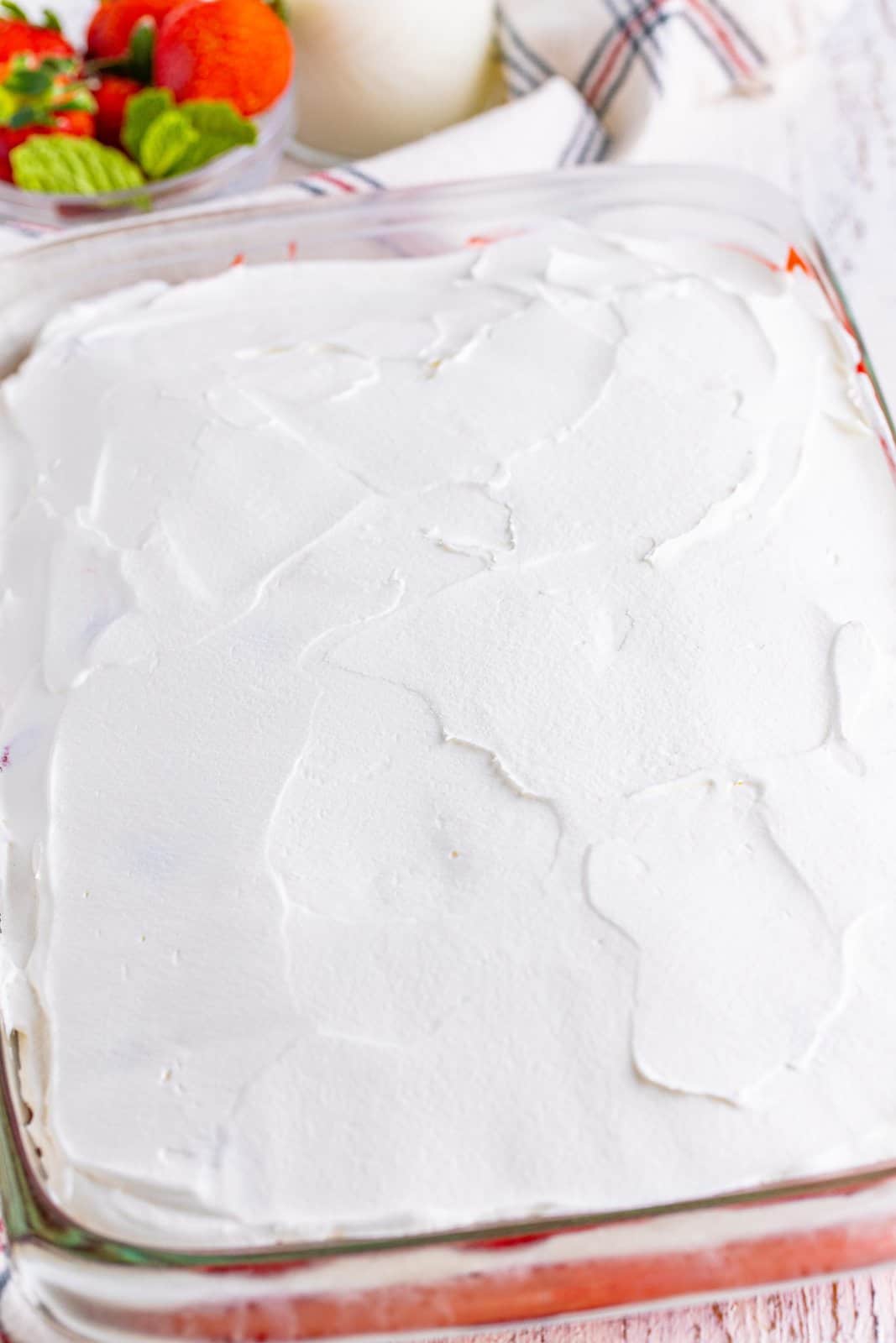 Whipped topping on a cake in a baking dish.