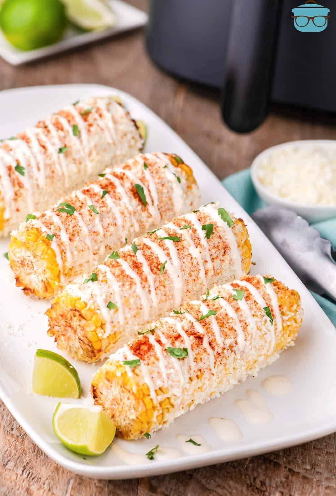 A plate with 4 pieces of Mexican Street Corn.