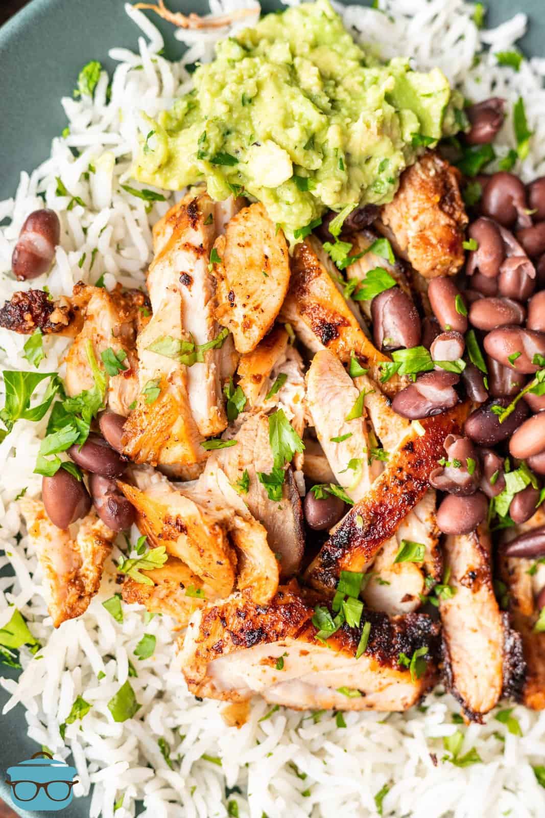 Looking down on a close up plate of rice, beans, and copycat chipotle chicken.