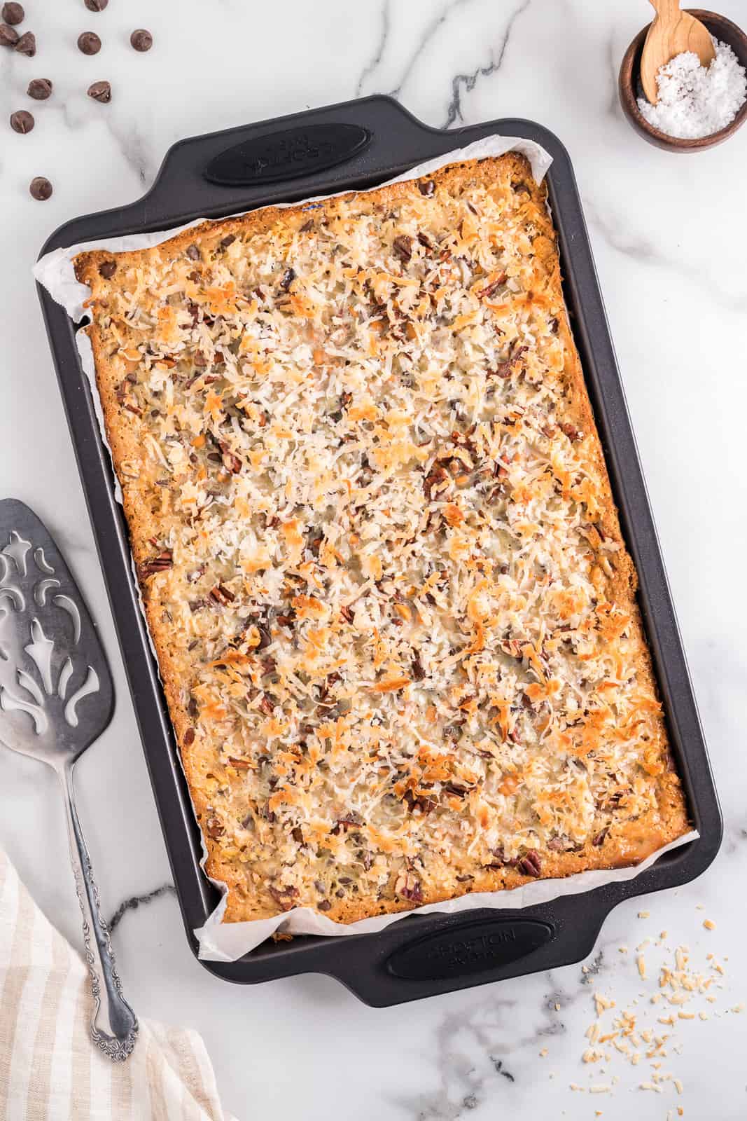 A baking sheet with baked but uncut Magic Cookie Bars.