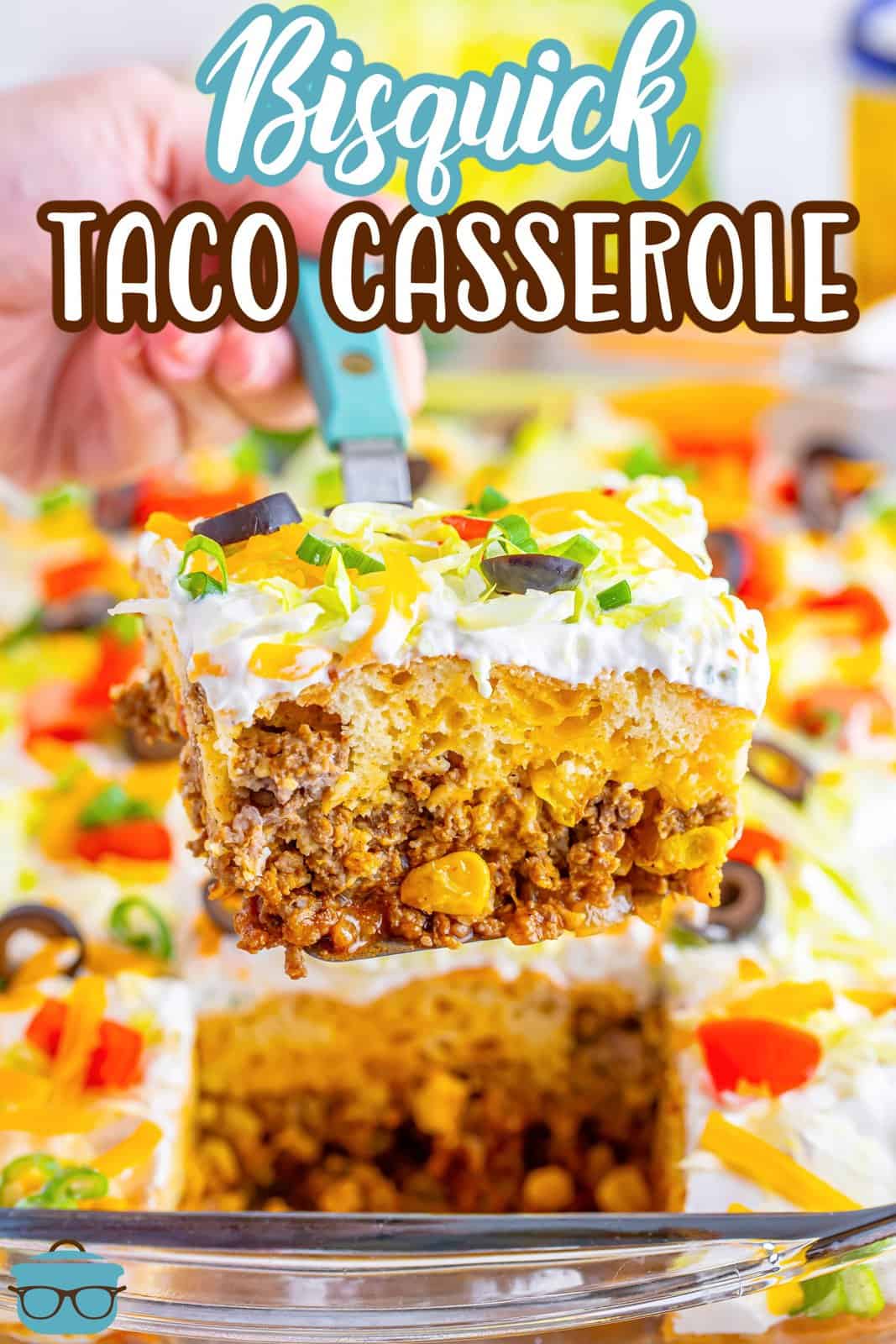 A serving utensil holding up a serving of taco casserole with bisquick.