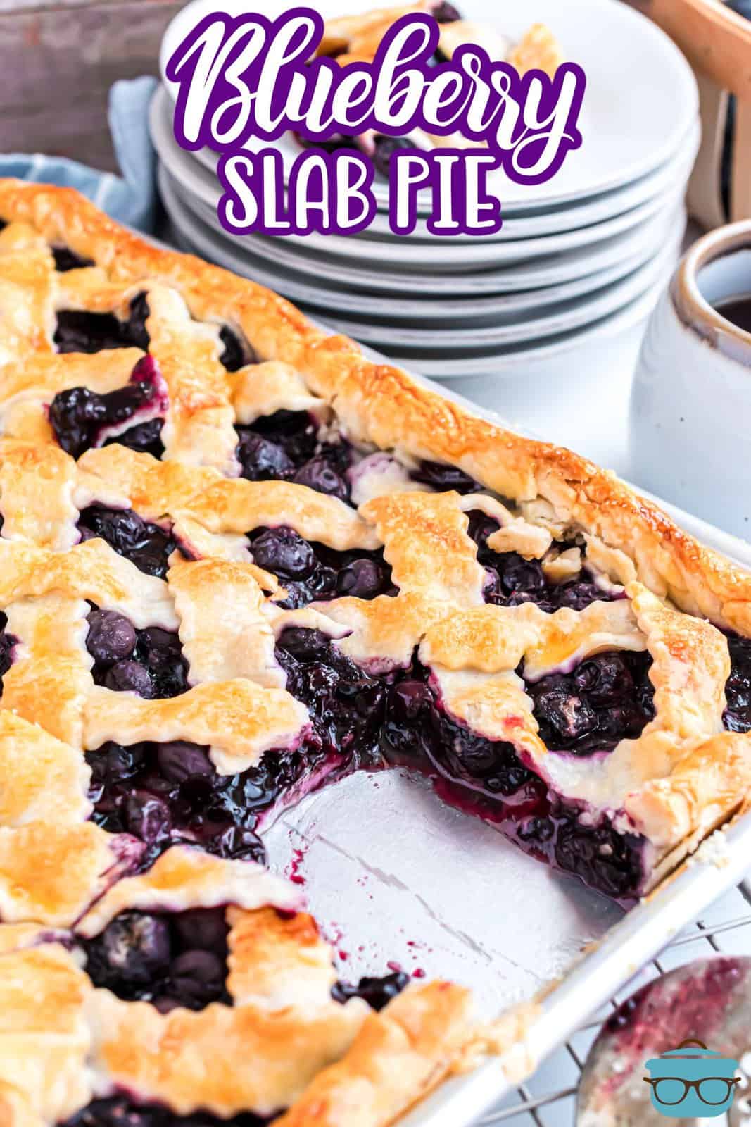 A sheet pan with a serving of Blueberry Slab Pie missing.