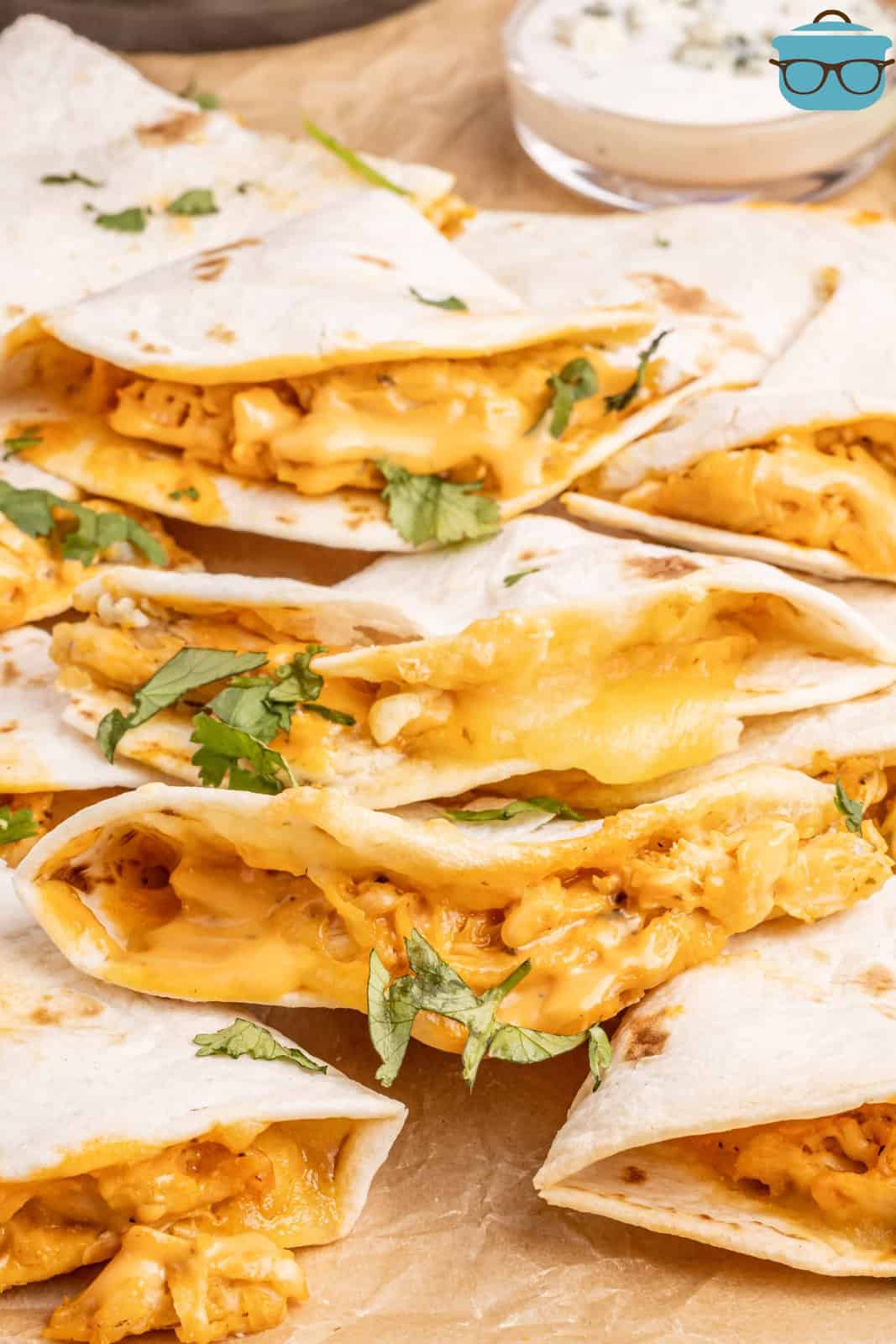 A piece of parchment paper with Air Fryer Buffalo Chicken Quesadillas. 