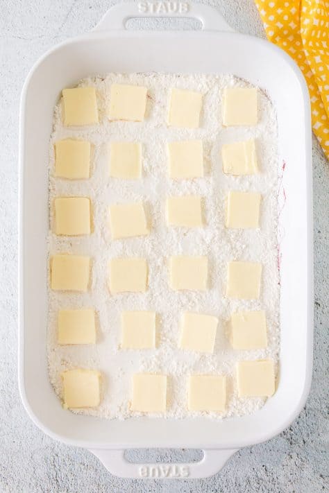 slices of butter placed on top of cake mix.