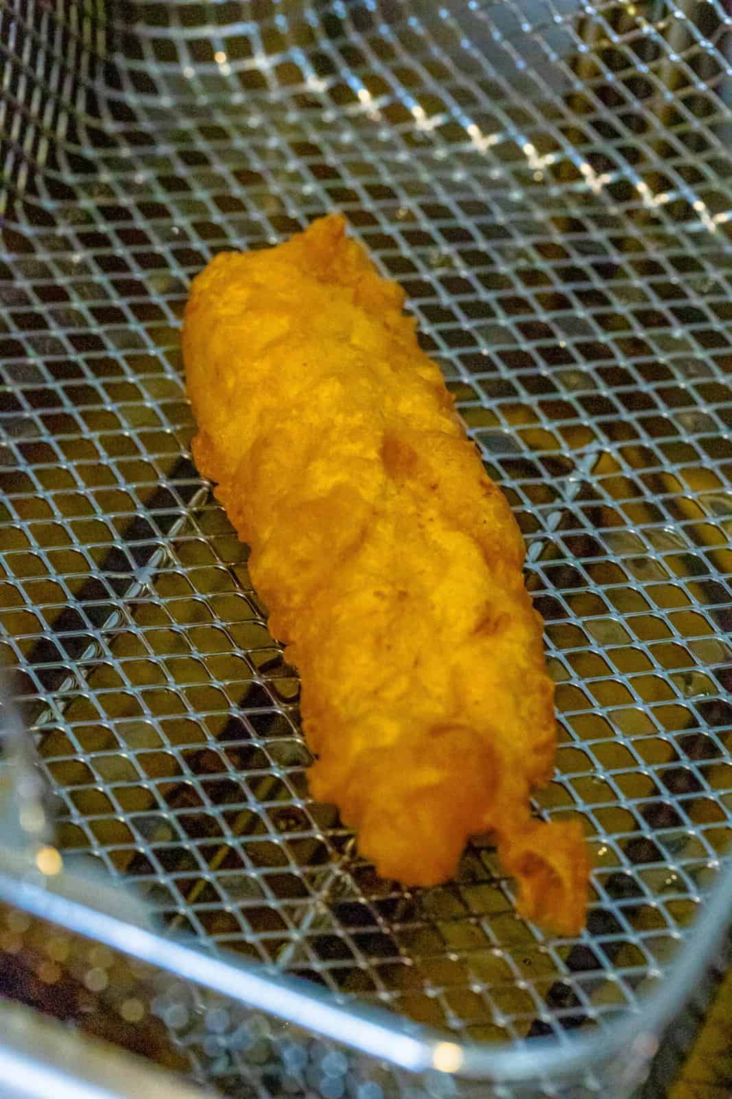 Freshly fried Chicken Crisper in a fryer basket. 