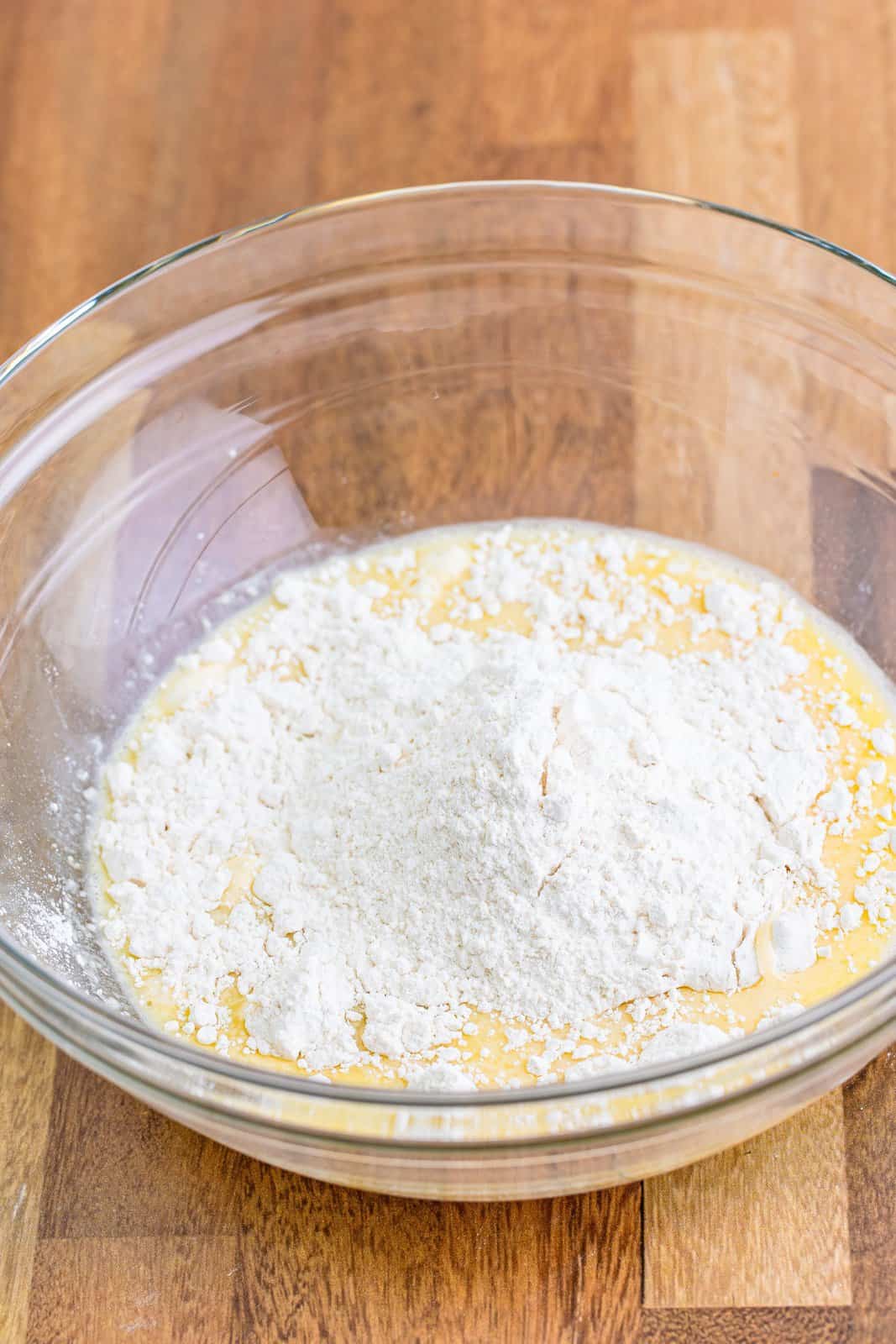 An egg mixture and flour in a mixing bowl.
