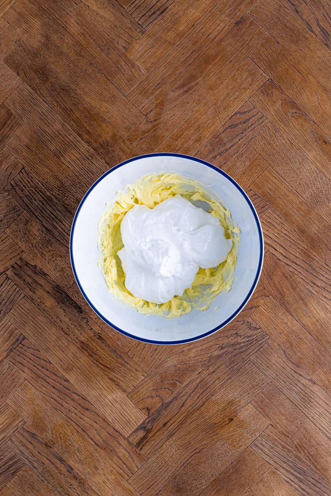 A mixing bowl with marshmallow fluff and butter.