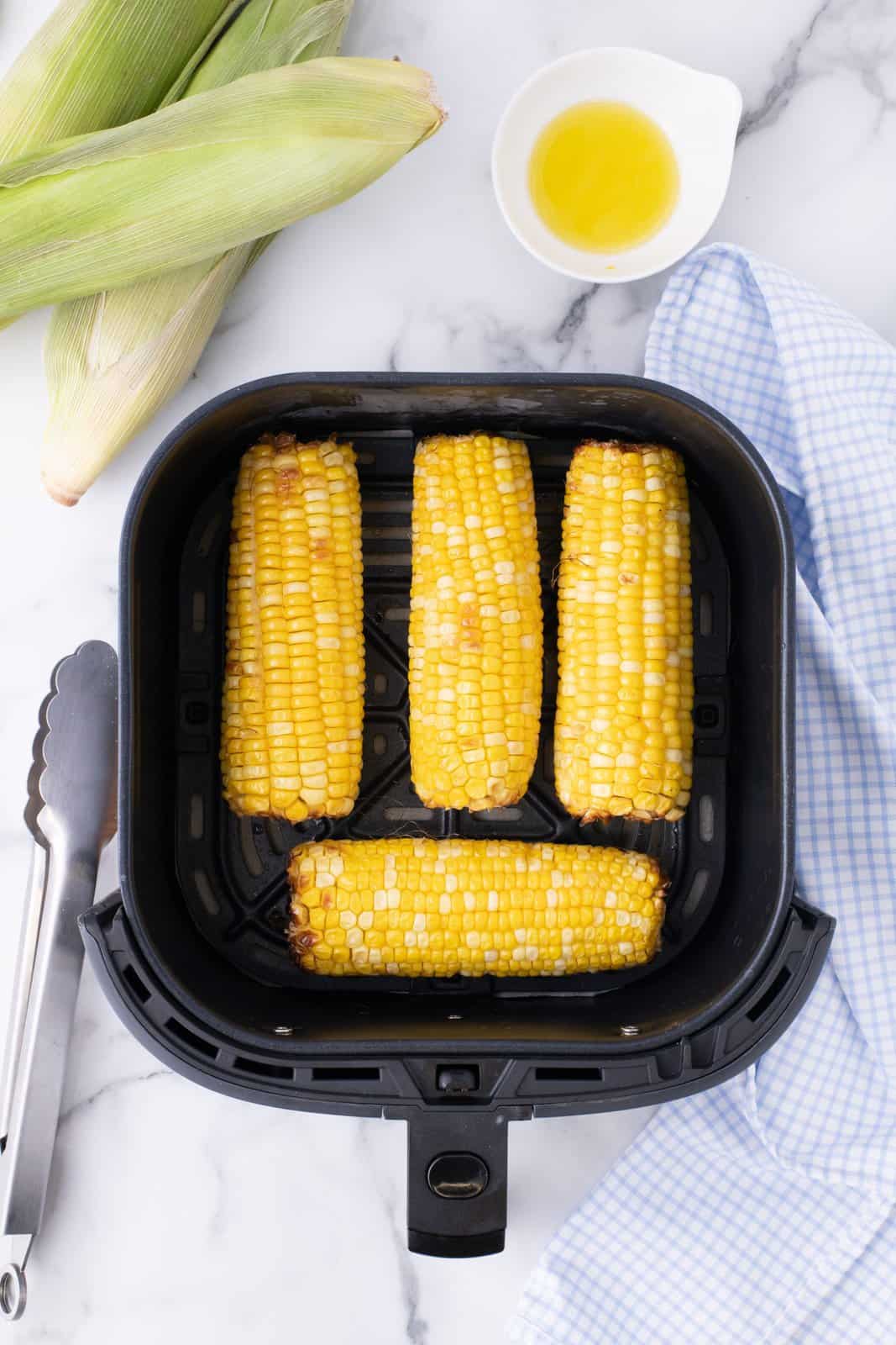 Four ears of corn in Air Fryer basket.