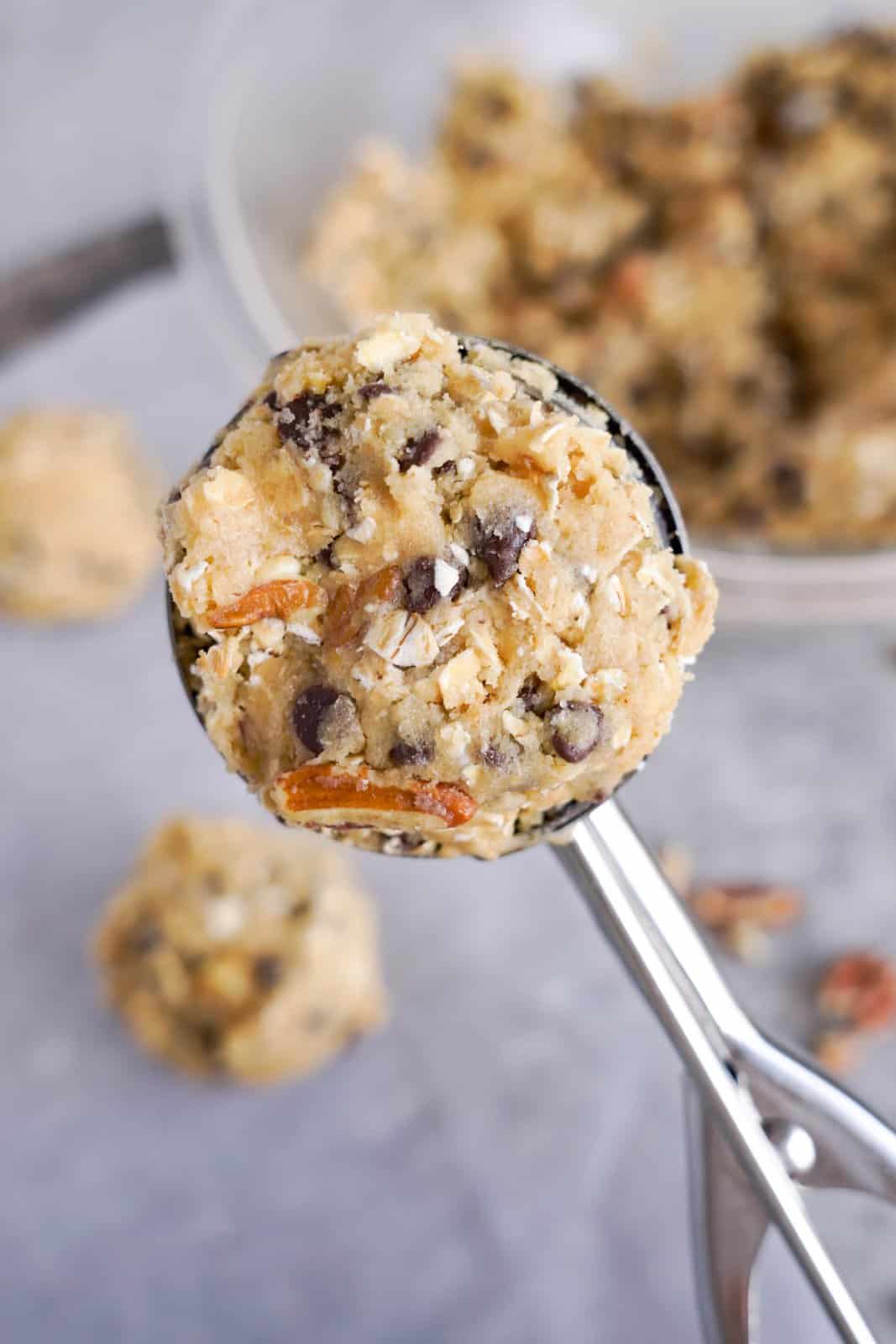 A cookie scooper holding some cookie dough.