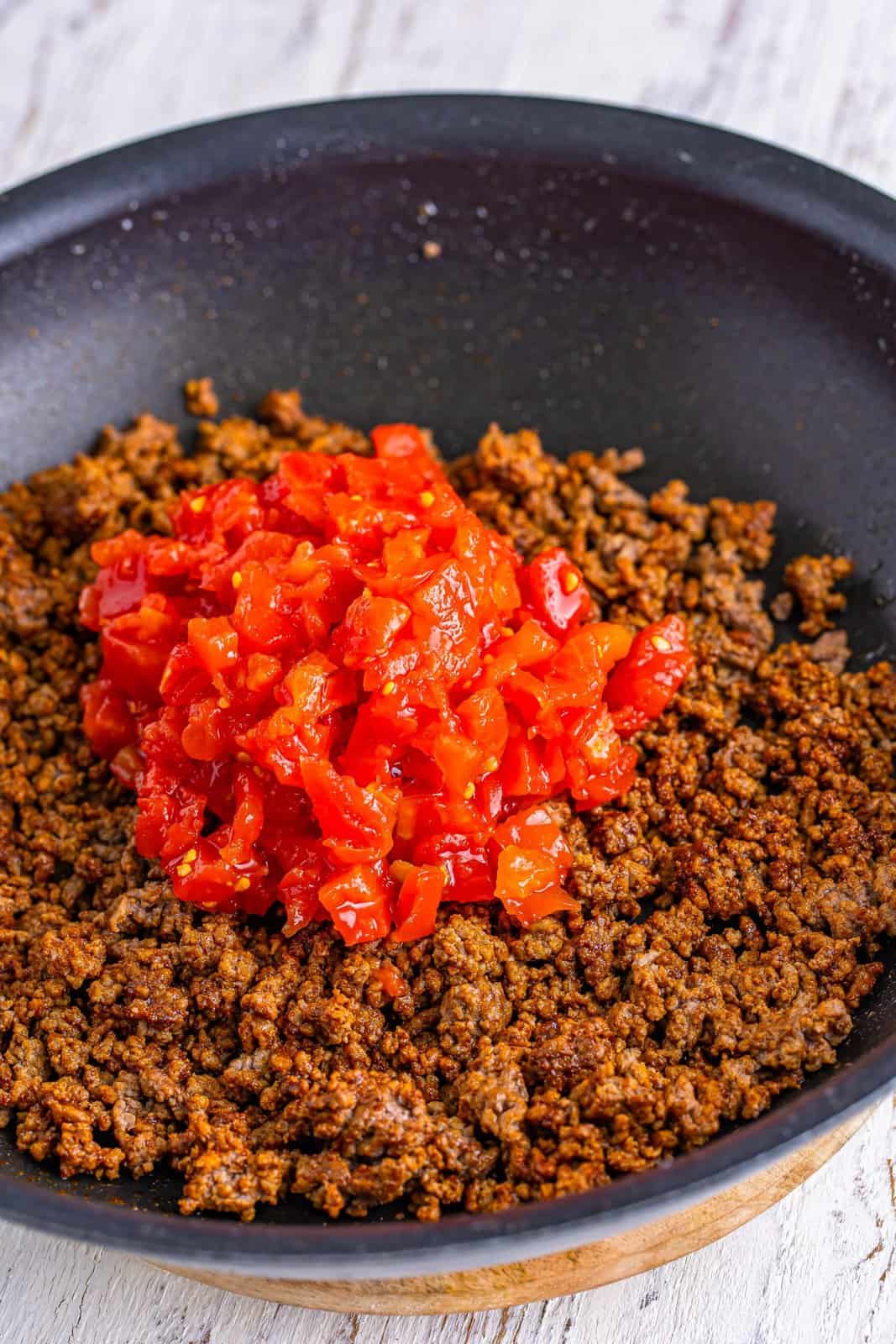 Rotel on top of cooked ground beef.