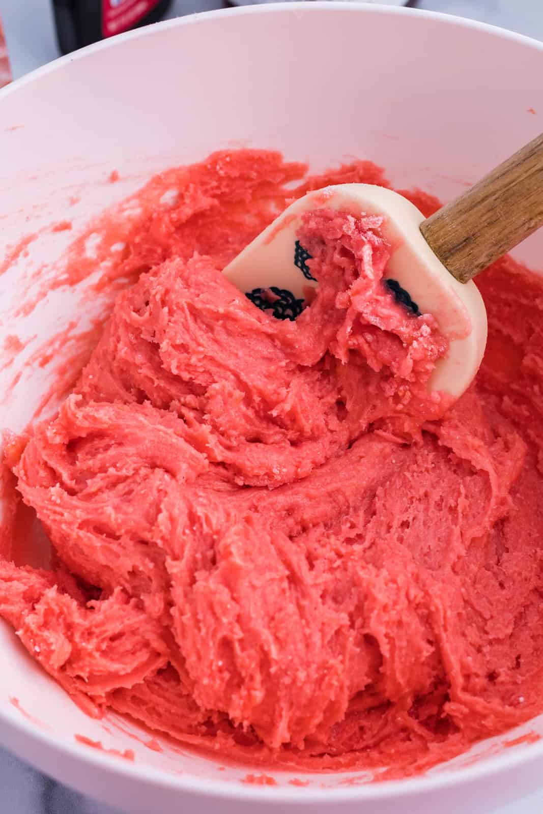 Pink brownie batter being mixed up in a mixing bowl.
