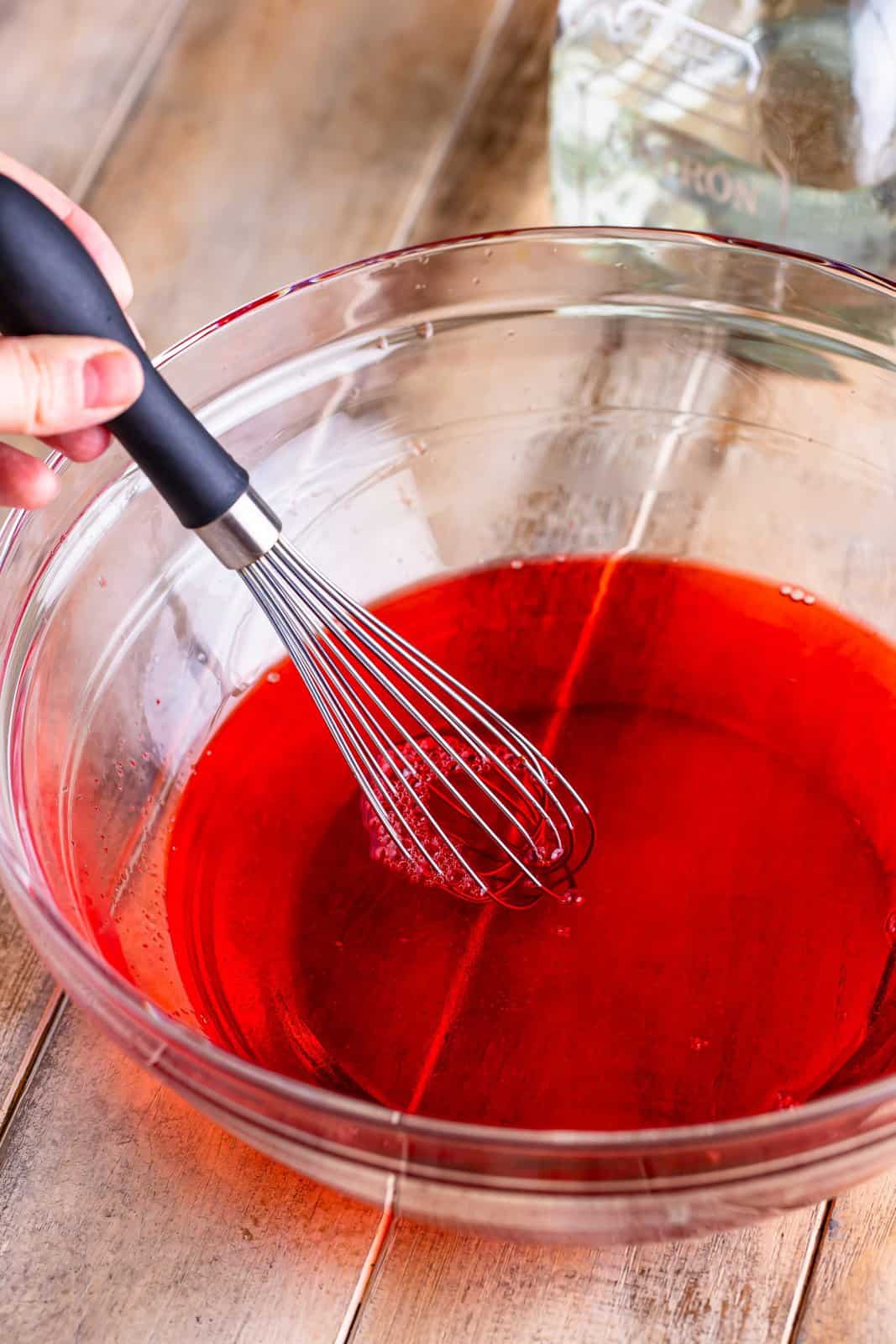 A mixing bowl with strawberry jello.