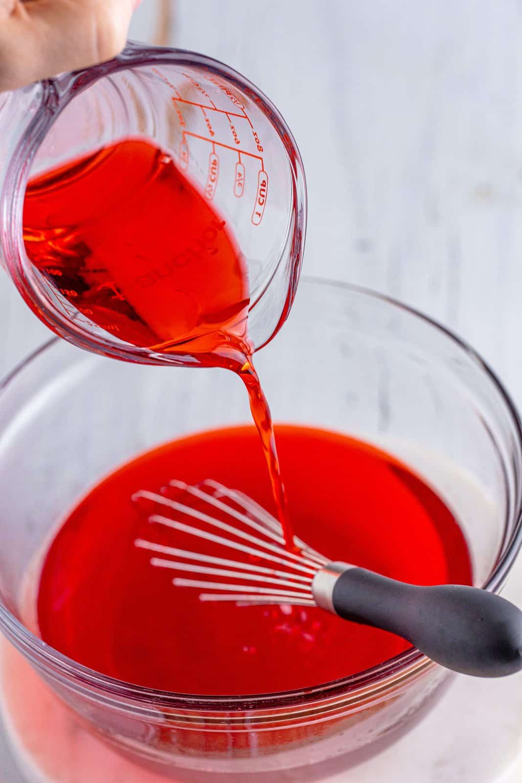 Grenadine being poured in Cherry Jello, water, and Tequila. 