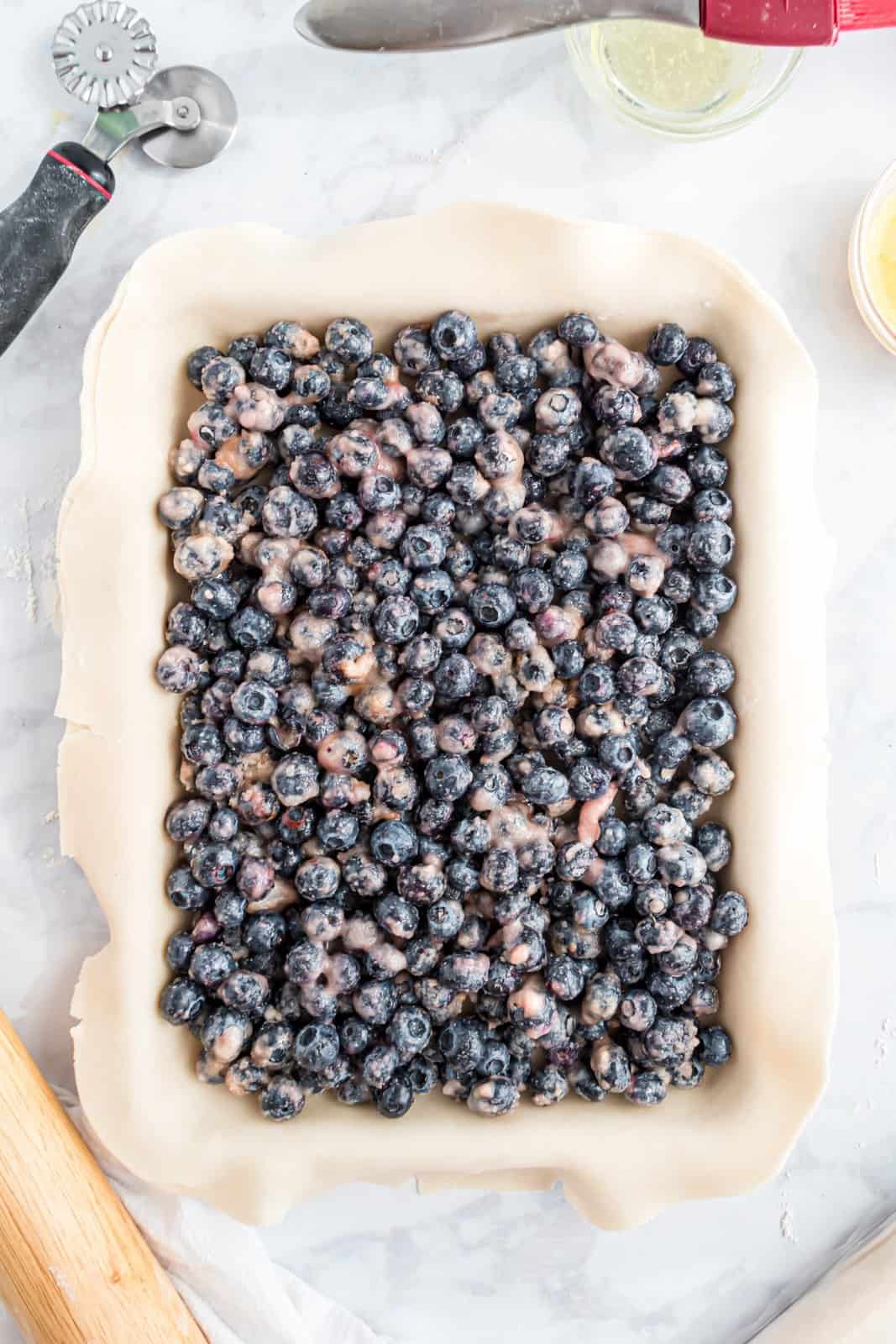 Blueberry pie filling on a sheet of dough.