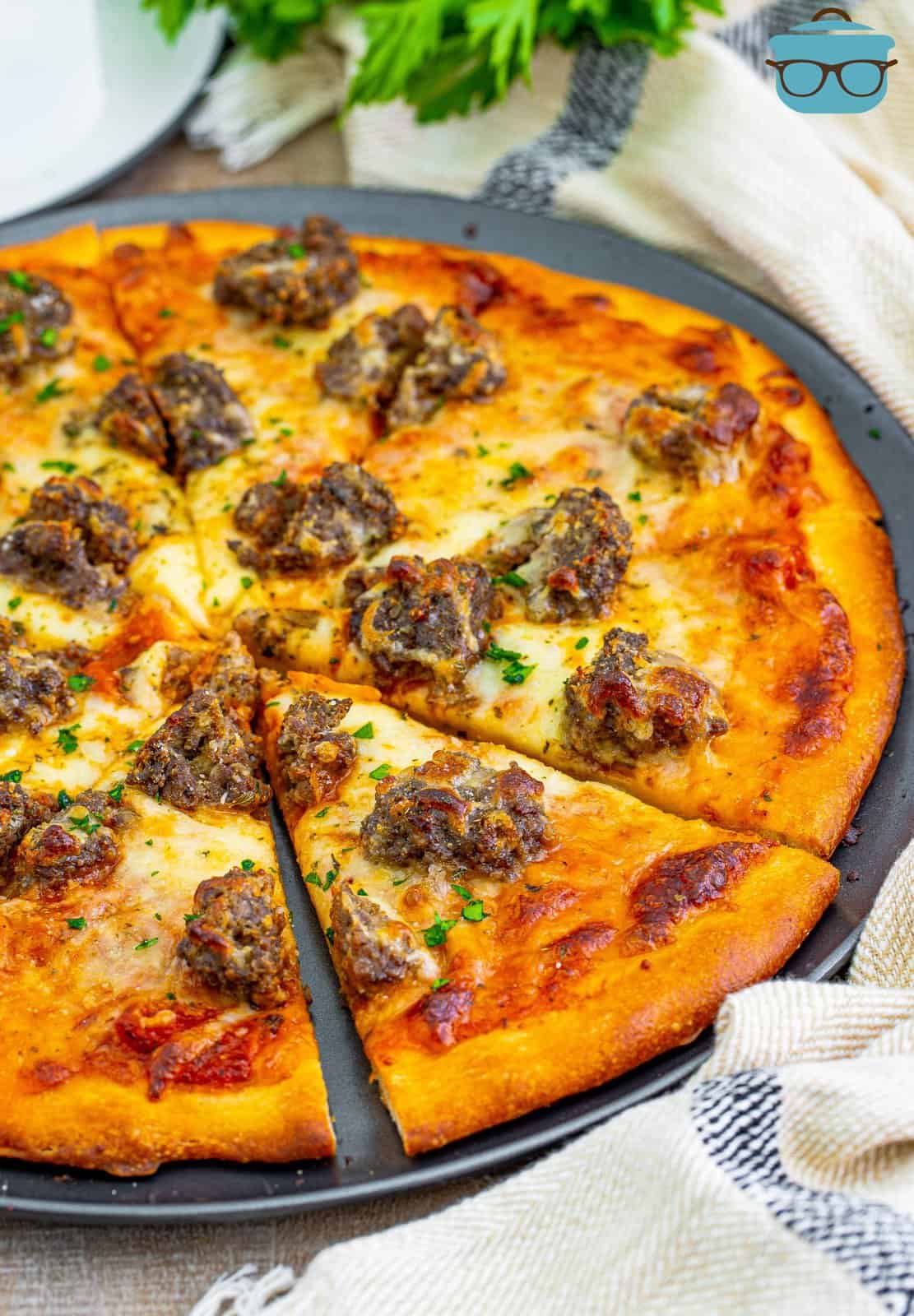 A serving dish of meatball pizza.