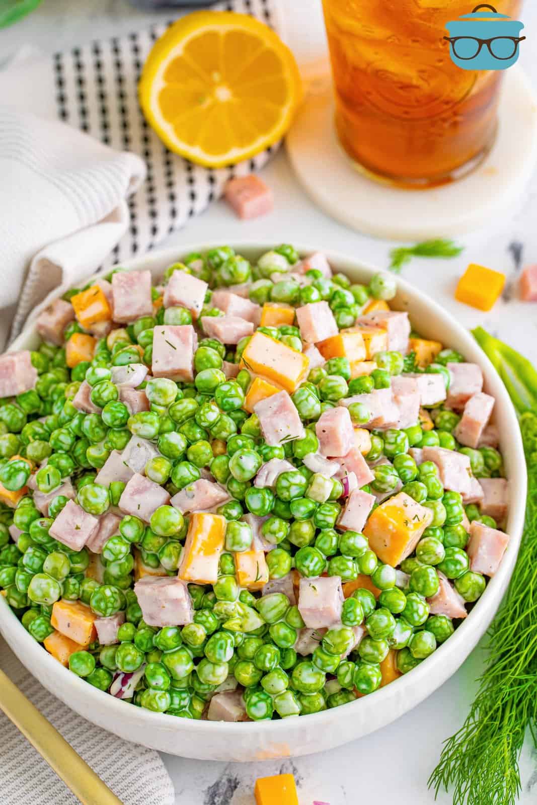 A bowl of pea salad with ham.