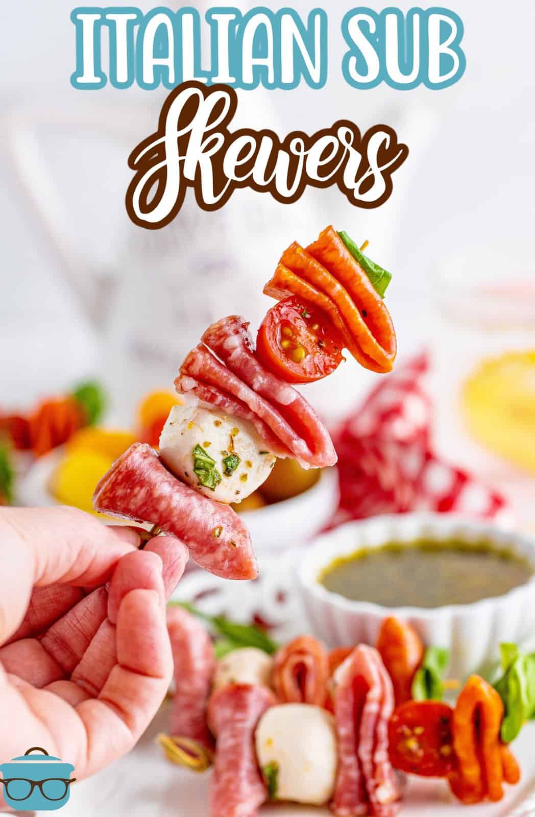 A hand holding a deconstructed Italian Sub on a skewer.