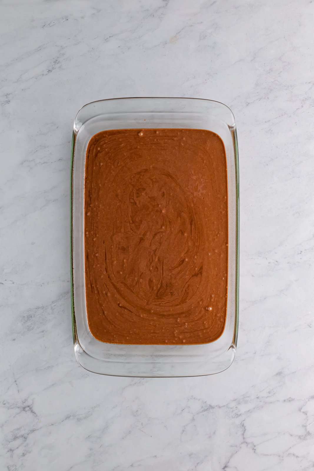 Chocolate cake batter in a baking dish.