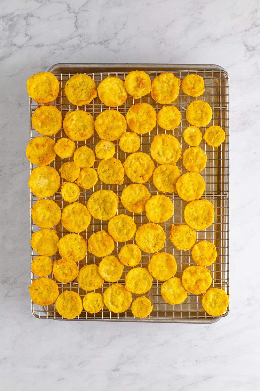 A wire rack with squash over a sheet pan.